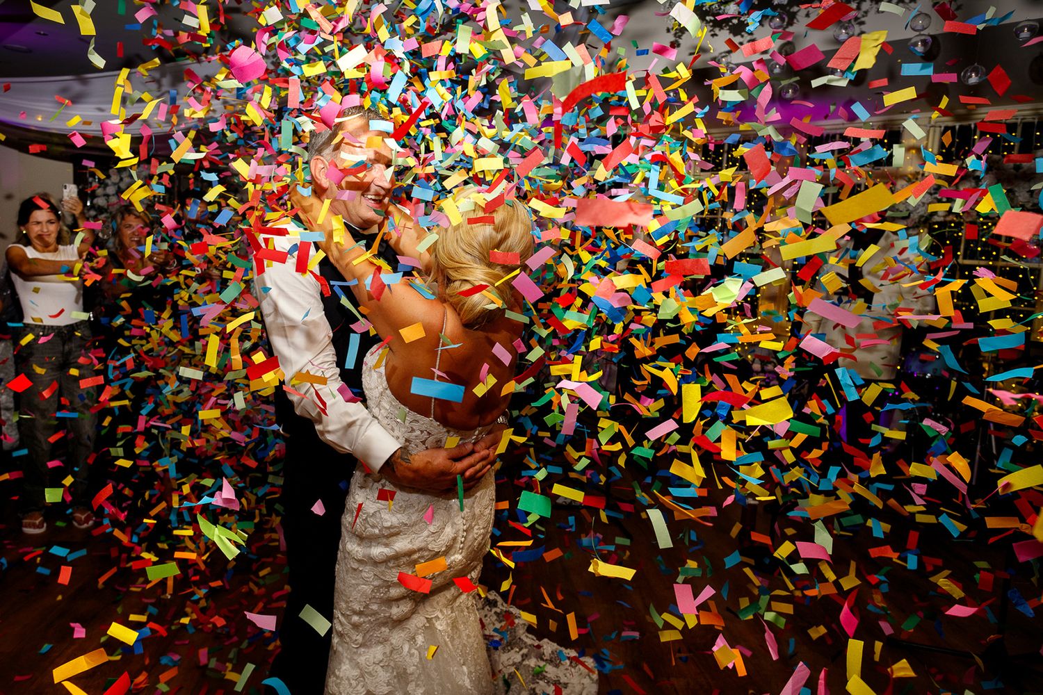 Mitton Hall Colorful confetti rains down during a celebration as people dance and celebrate beneath the falling paper pieces.