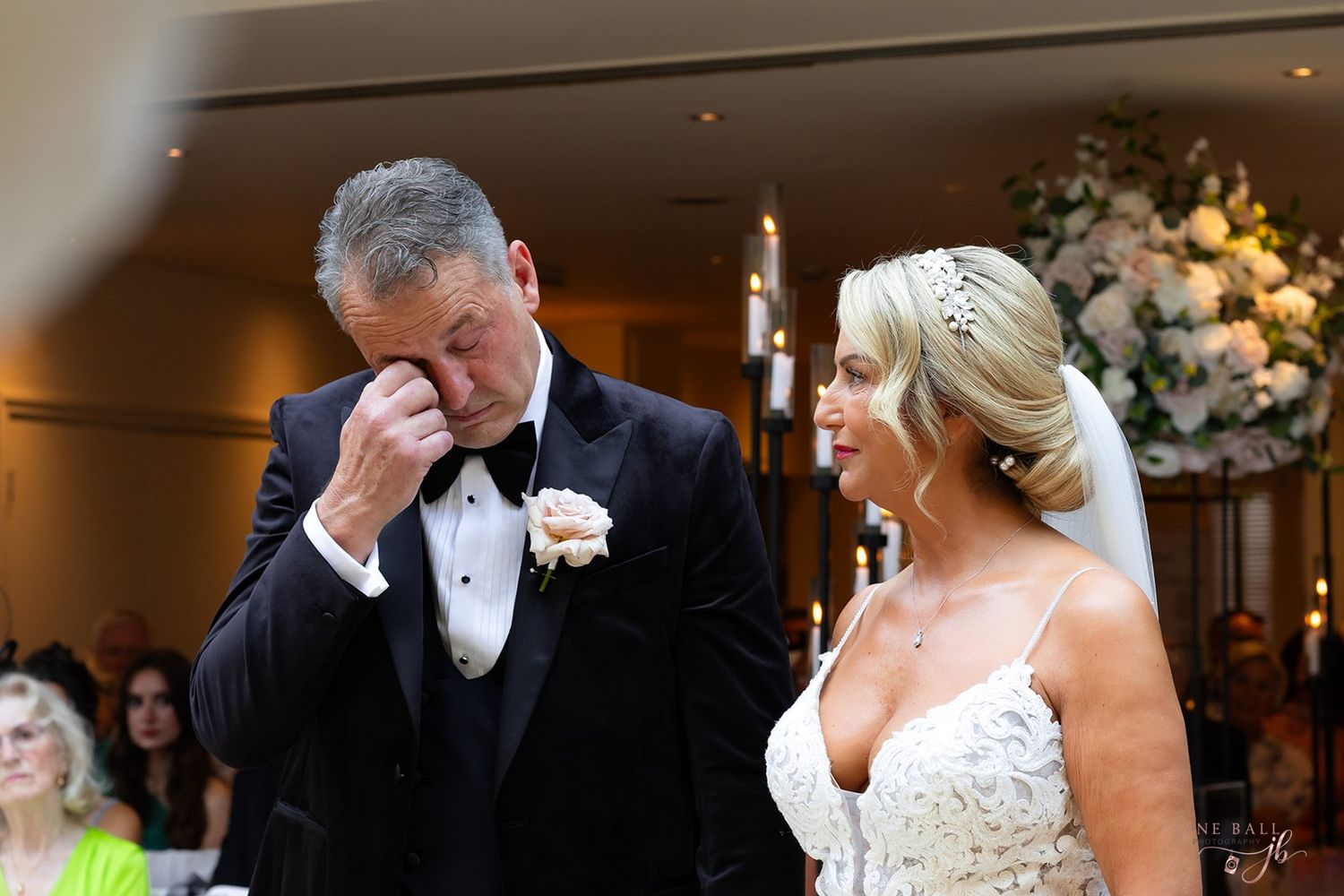 An emotional moment during a wedding ceremony with a couple in formal attire standing together.