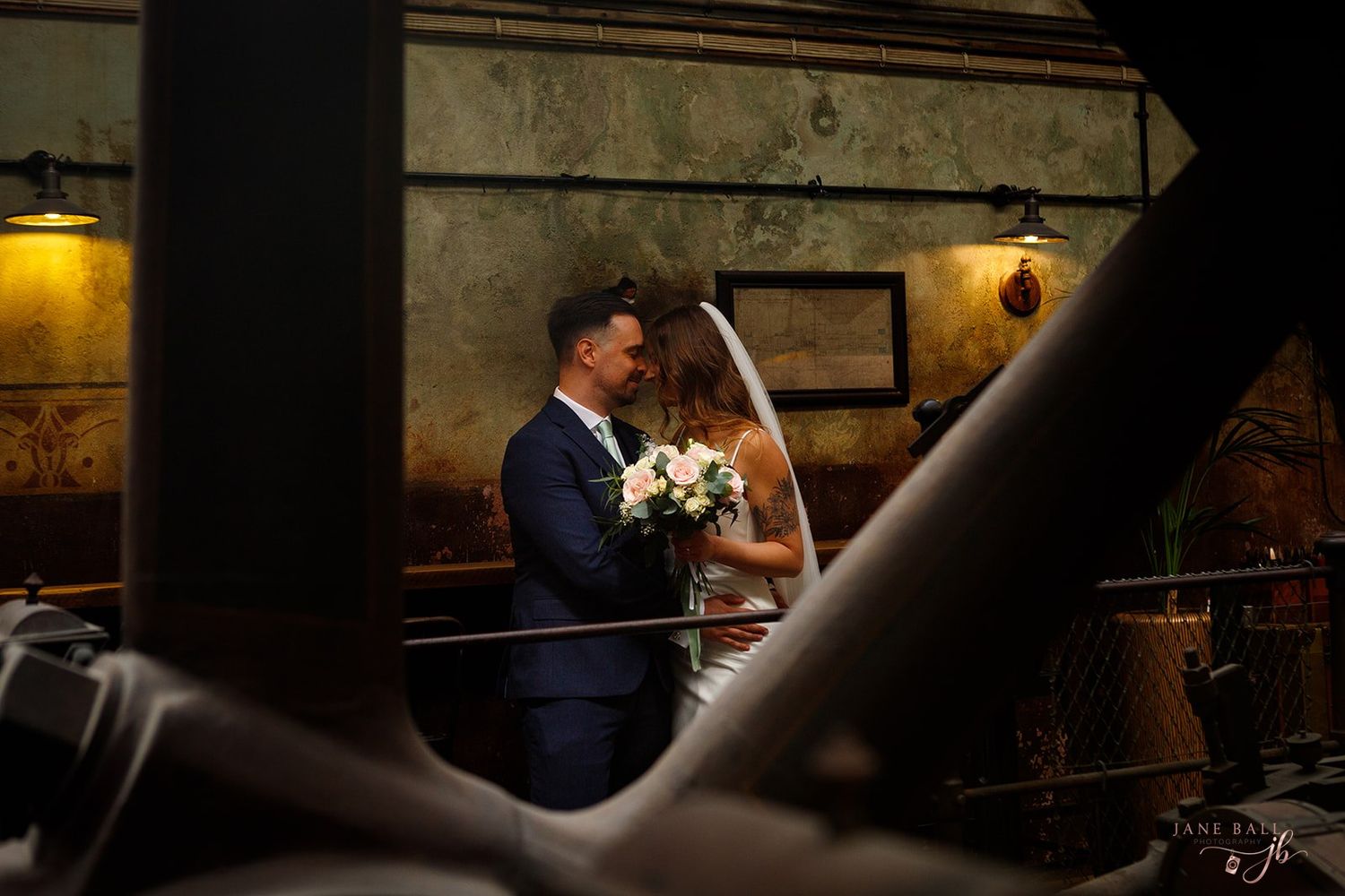 A couple shares an intimate dance in a dimly lit ballroom with romantic mood lighting and elegant decor.