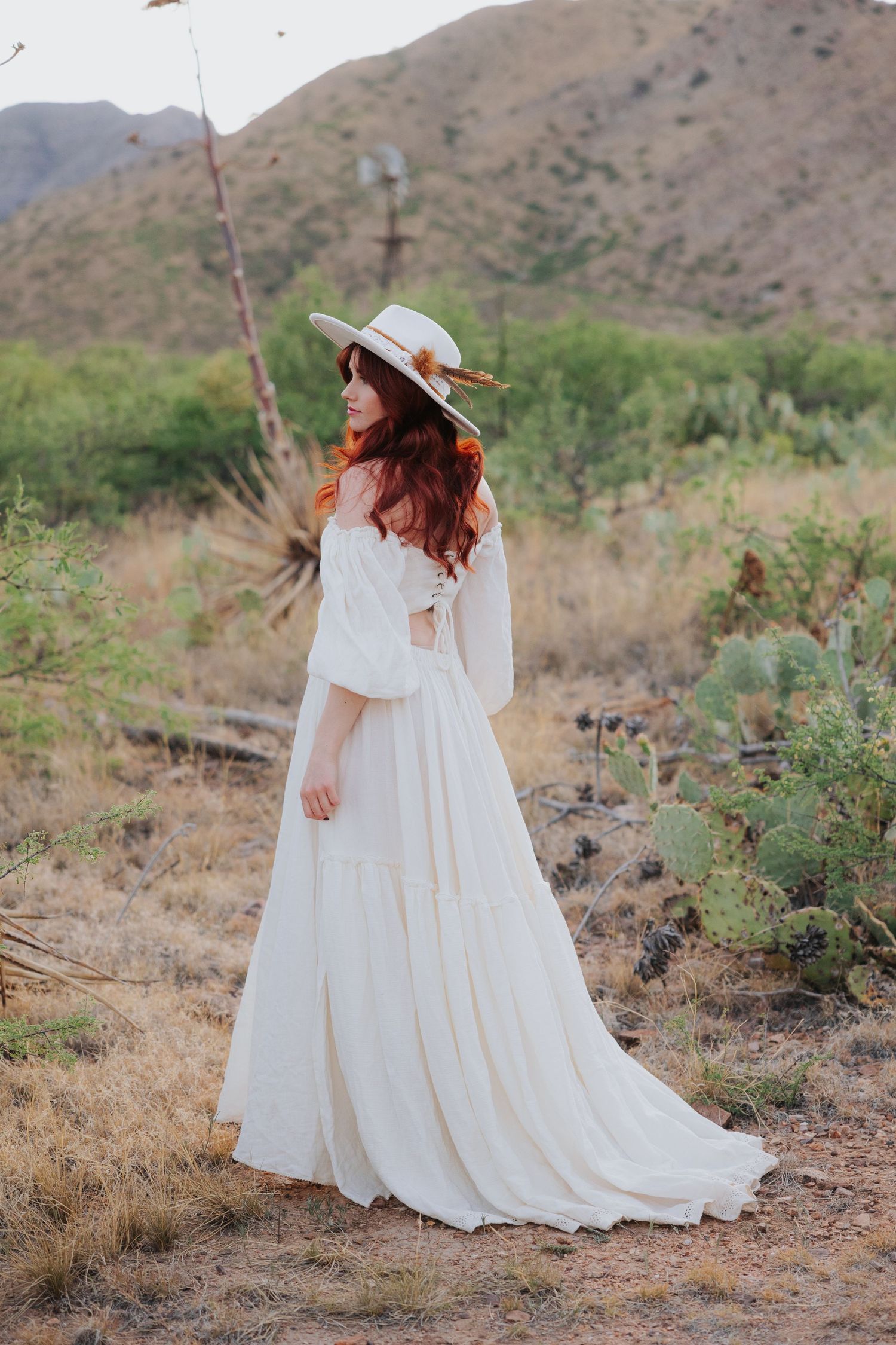 An ethereal white dress flows gracefully across desert terrain with mountains in the background.