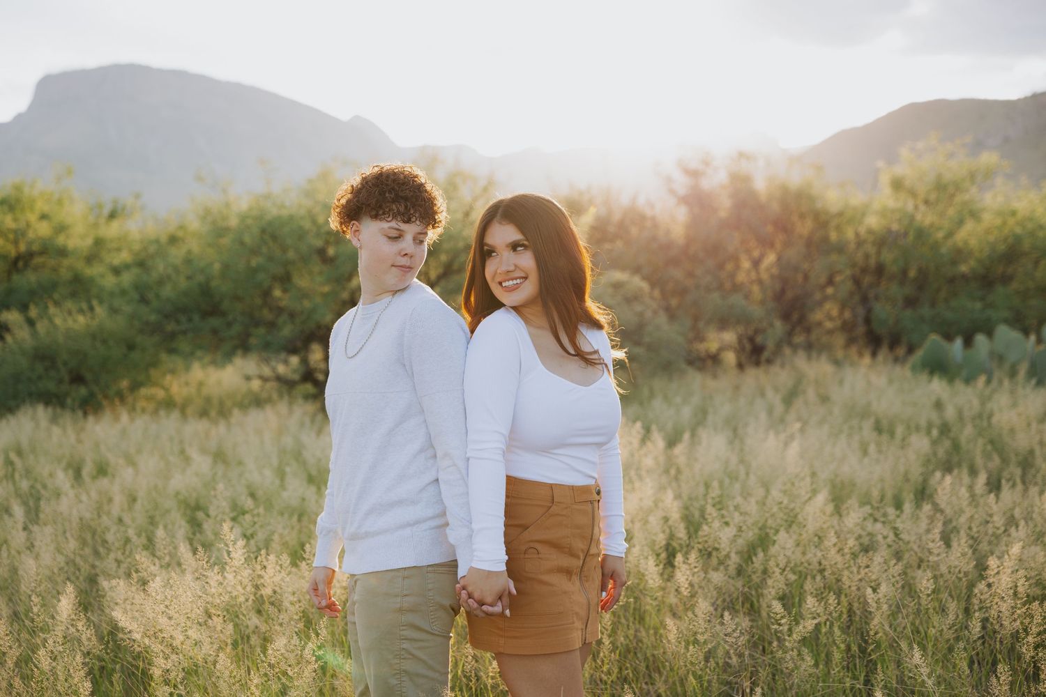 Romantic desert photoshoot with mountain backdrop during golden hour.