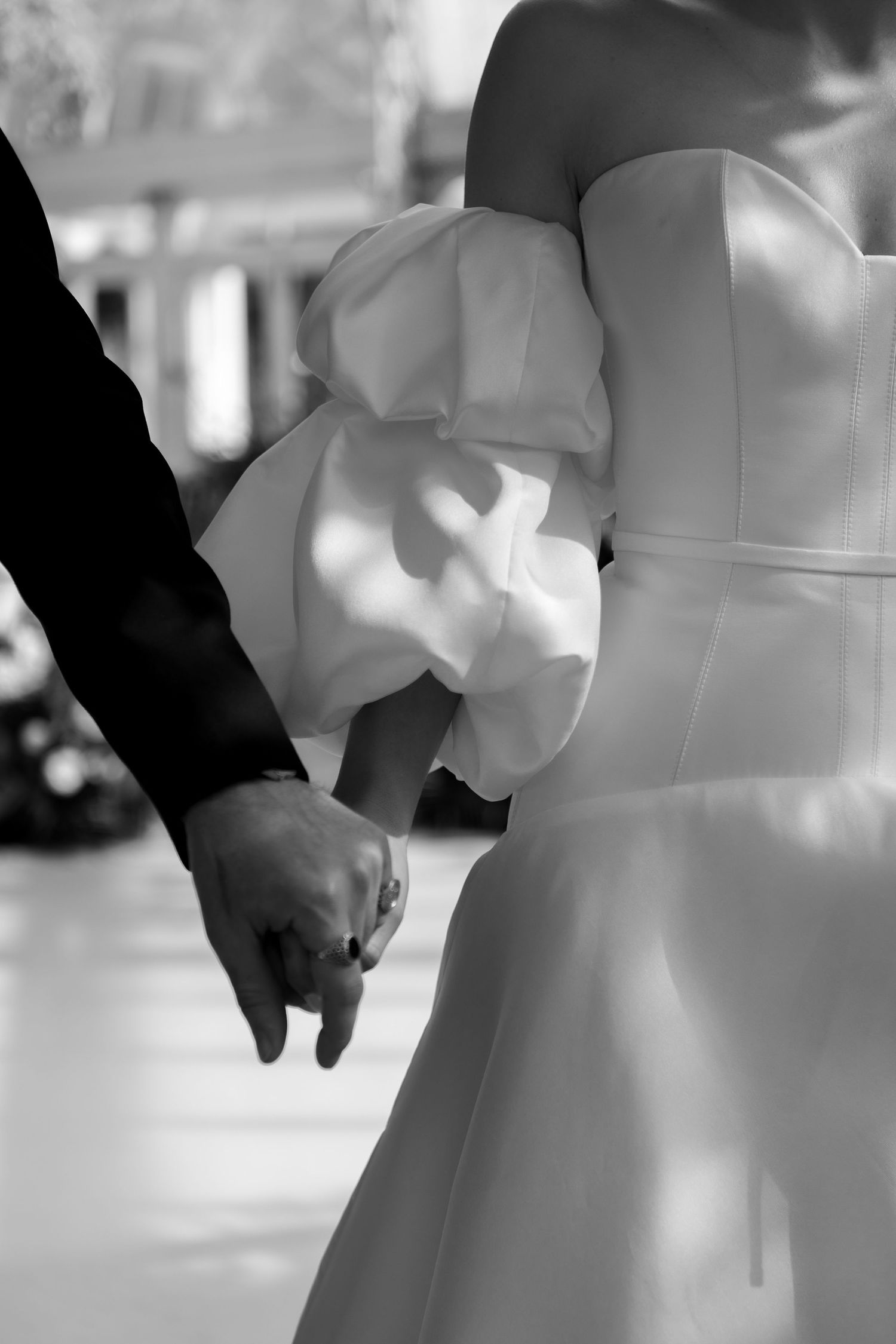 detail shot of bride and groom holding hands showing detailing of puffy sleeves on her dress