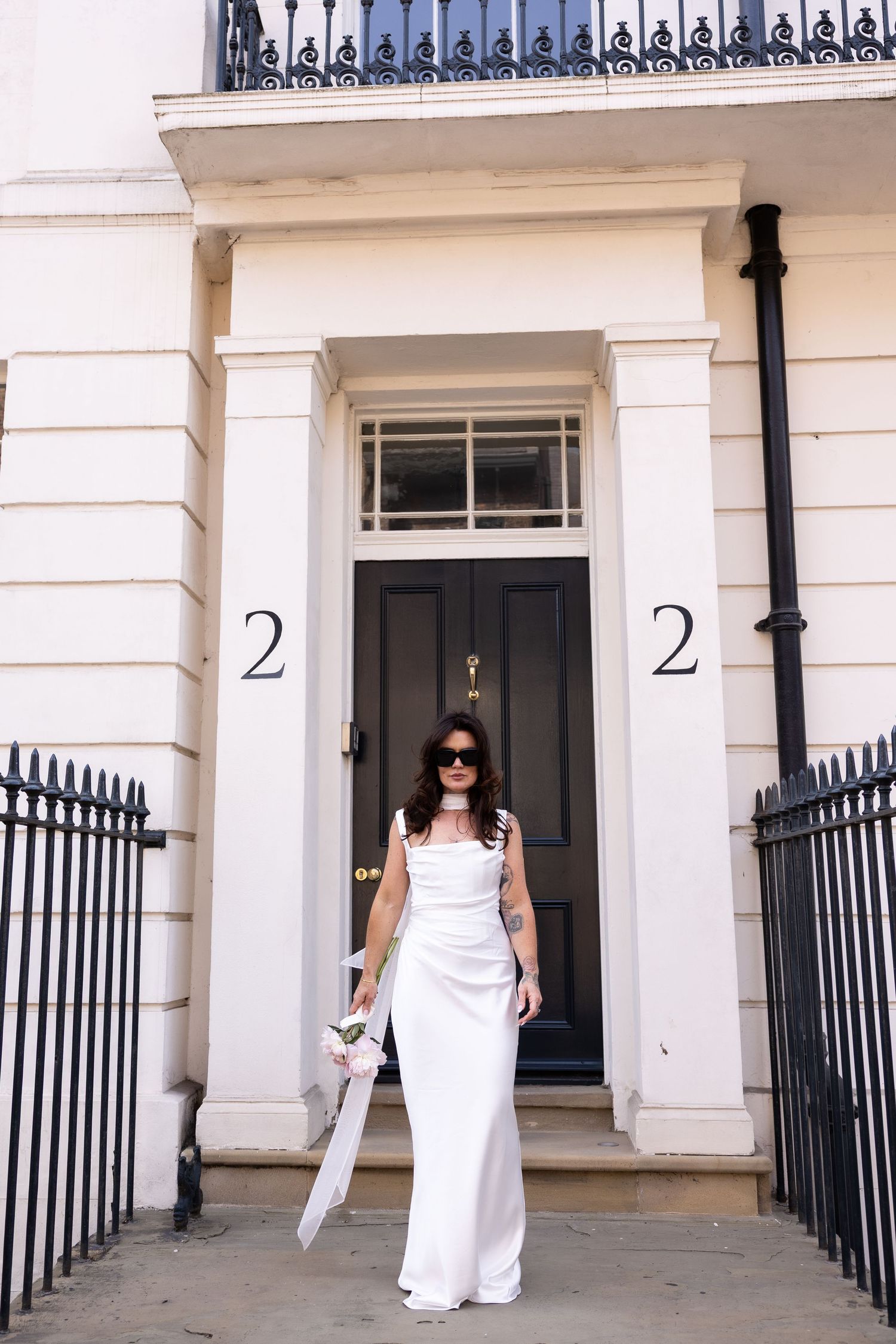 bride posing infront of white houses in the streets of York after her legal ceremony at York registry office creating editorial image