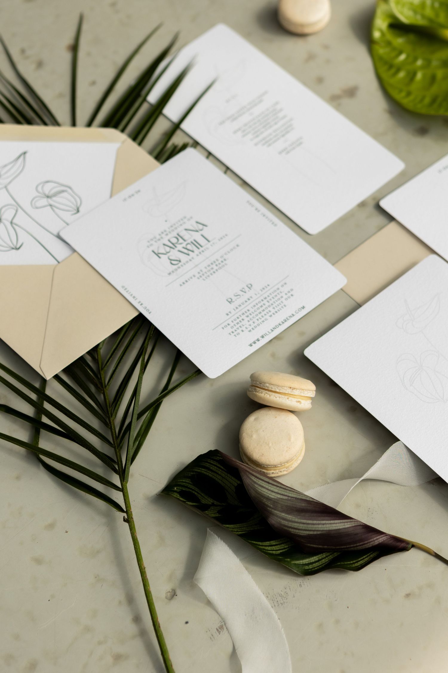 flat lay image of macaroons, invites & leaves to create shadow on bridal/wedding shoot