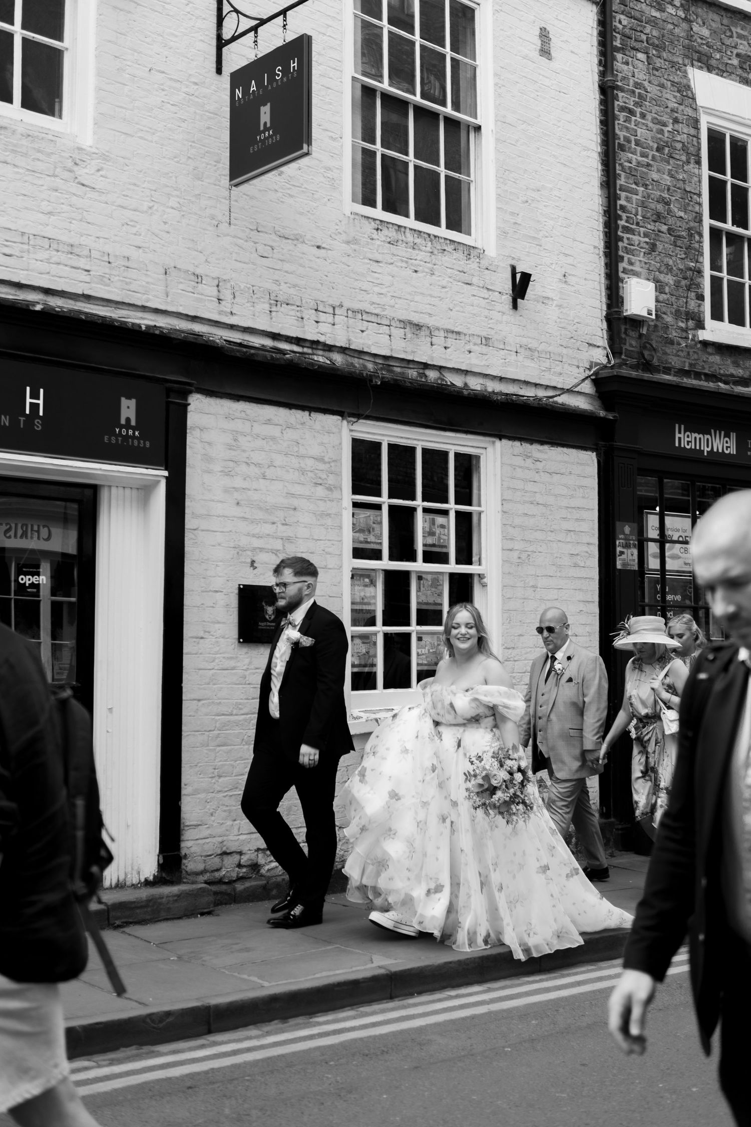 bride and groom with family walking through the streets of York on their wedding day