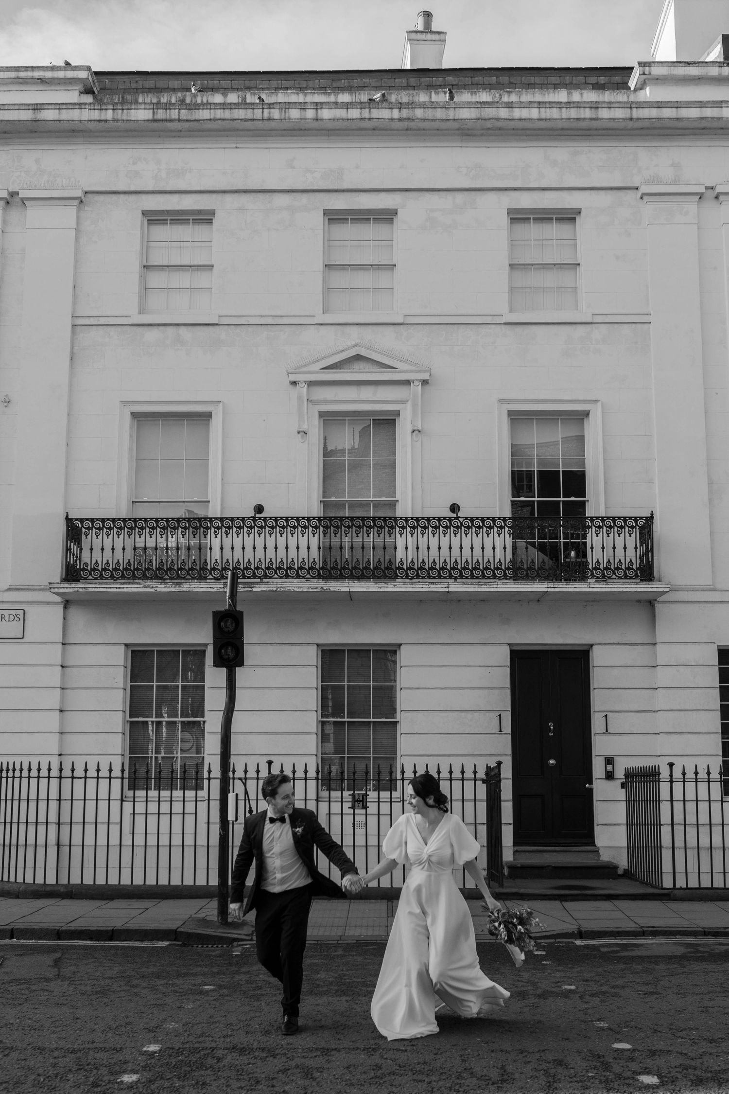 bride and groom running over a crossing in York City centre on their wedding day