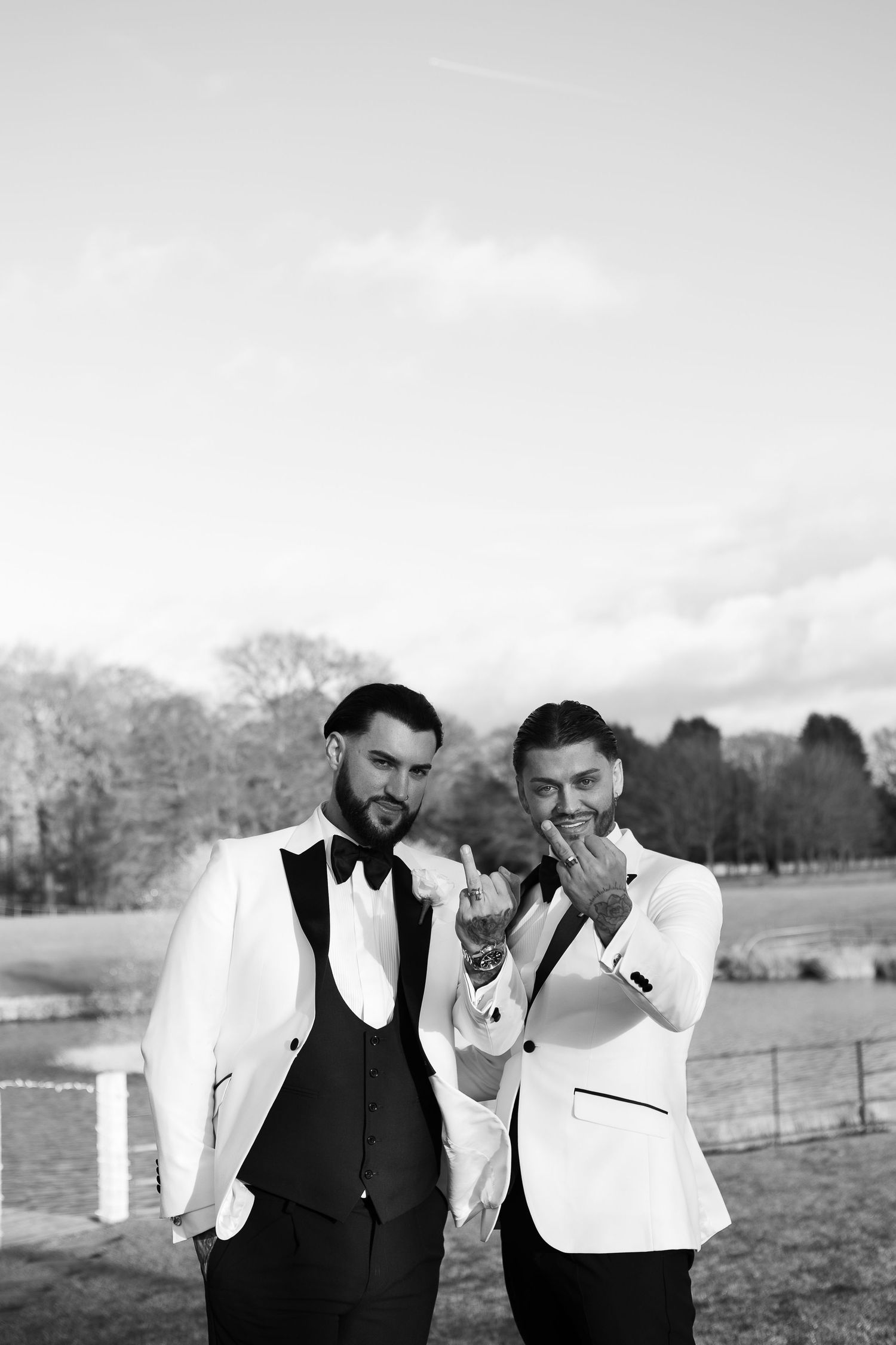 both grooms holding hands up to the camera showcasing their wedding rings at merry dale manor wedding venue based in Cheshire