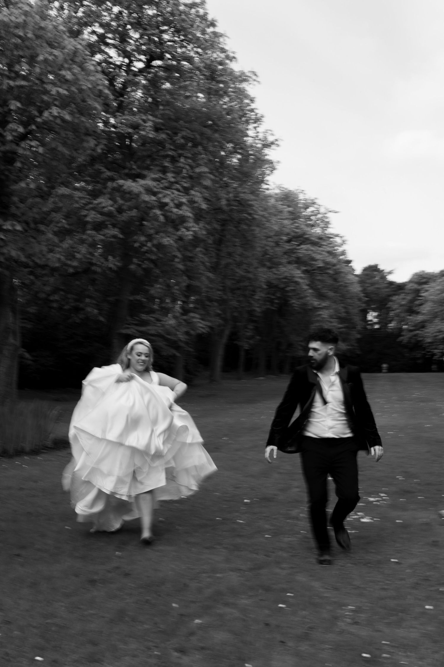 bride & groom running through the gardens of Crathorne Hall Yarm in the northeast on their wedding day