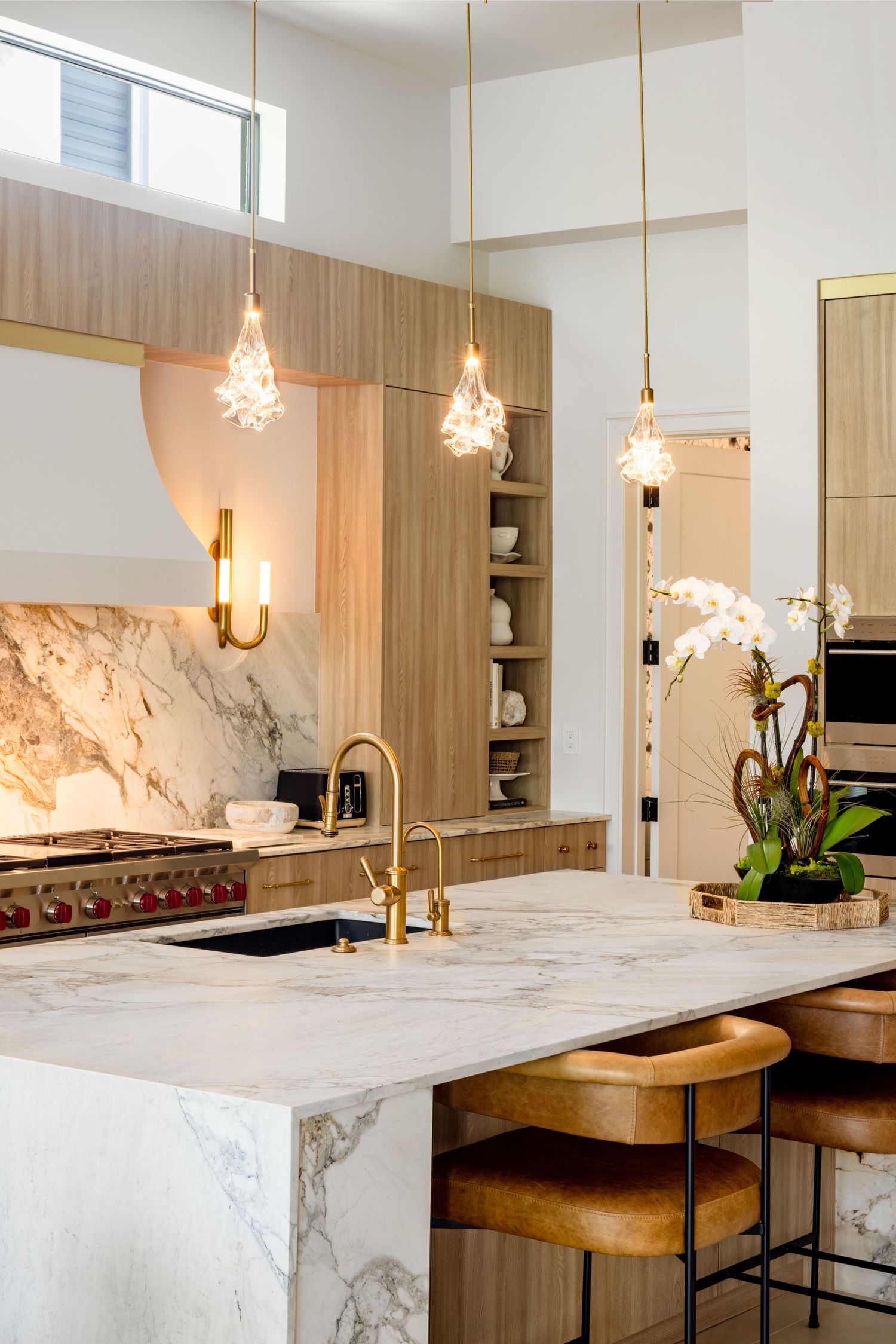 Architectural interior photography of a luxury kitchen featuring marble countertops, custom cabinetry, and designer lighting.
