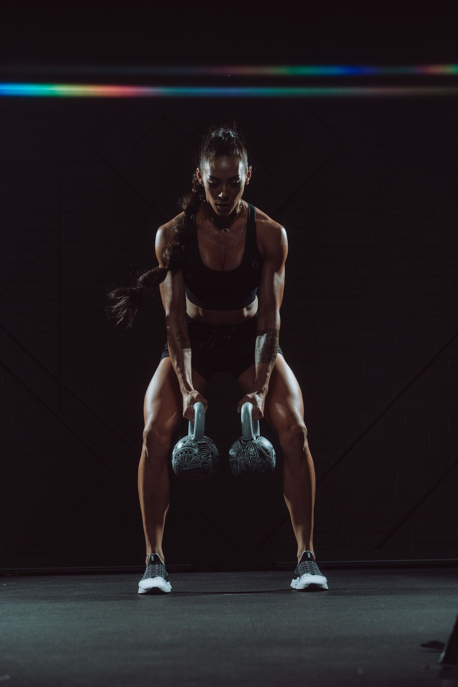 dramatic fitness portrait photograph of Hannah Eden holding two kettlebells
