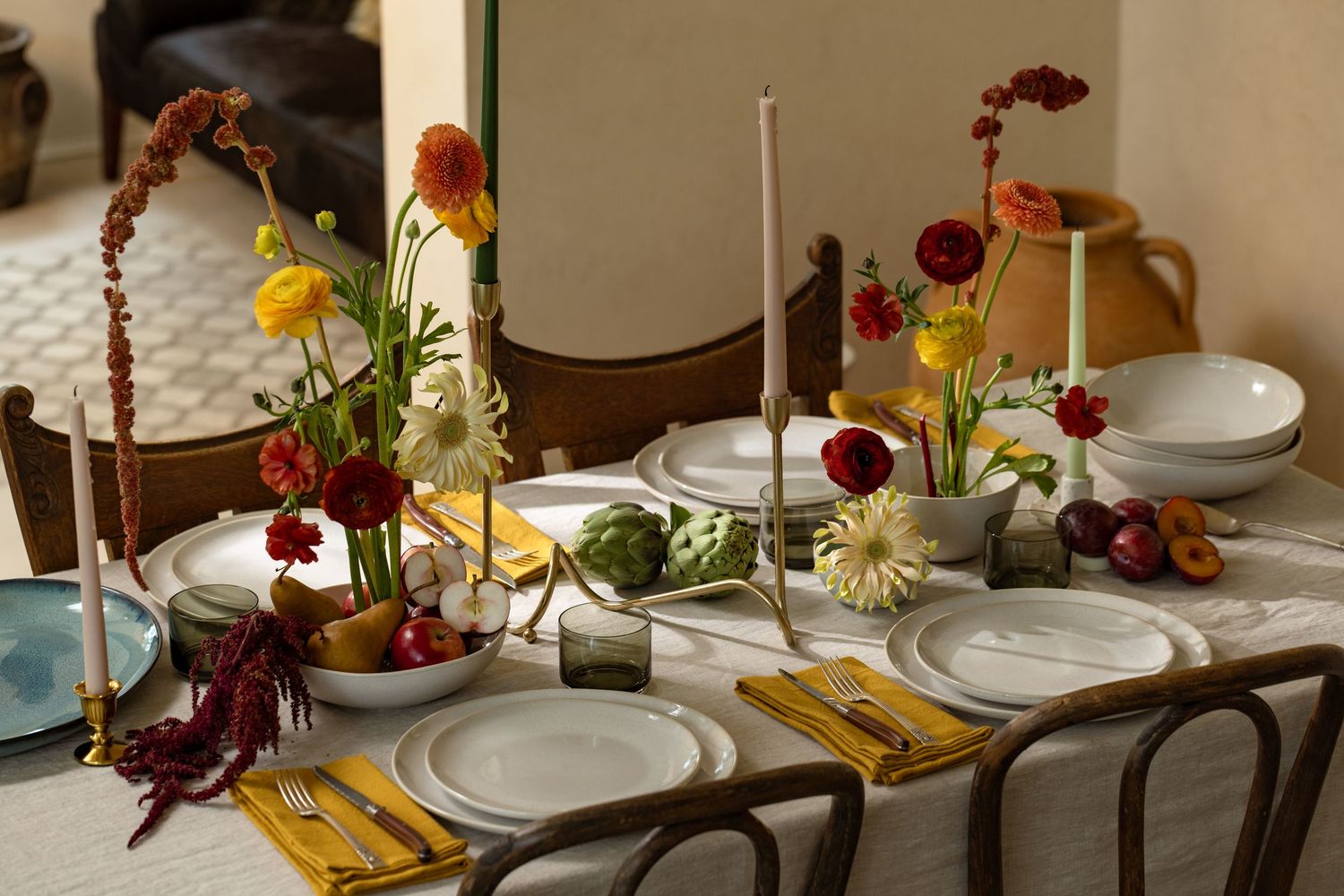 Product photography of ceramic dinnerware styled on a dining table with floral arrangements, linens, and warm natural light.