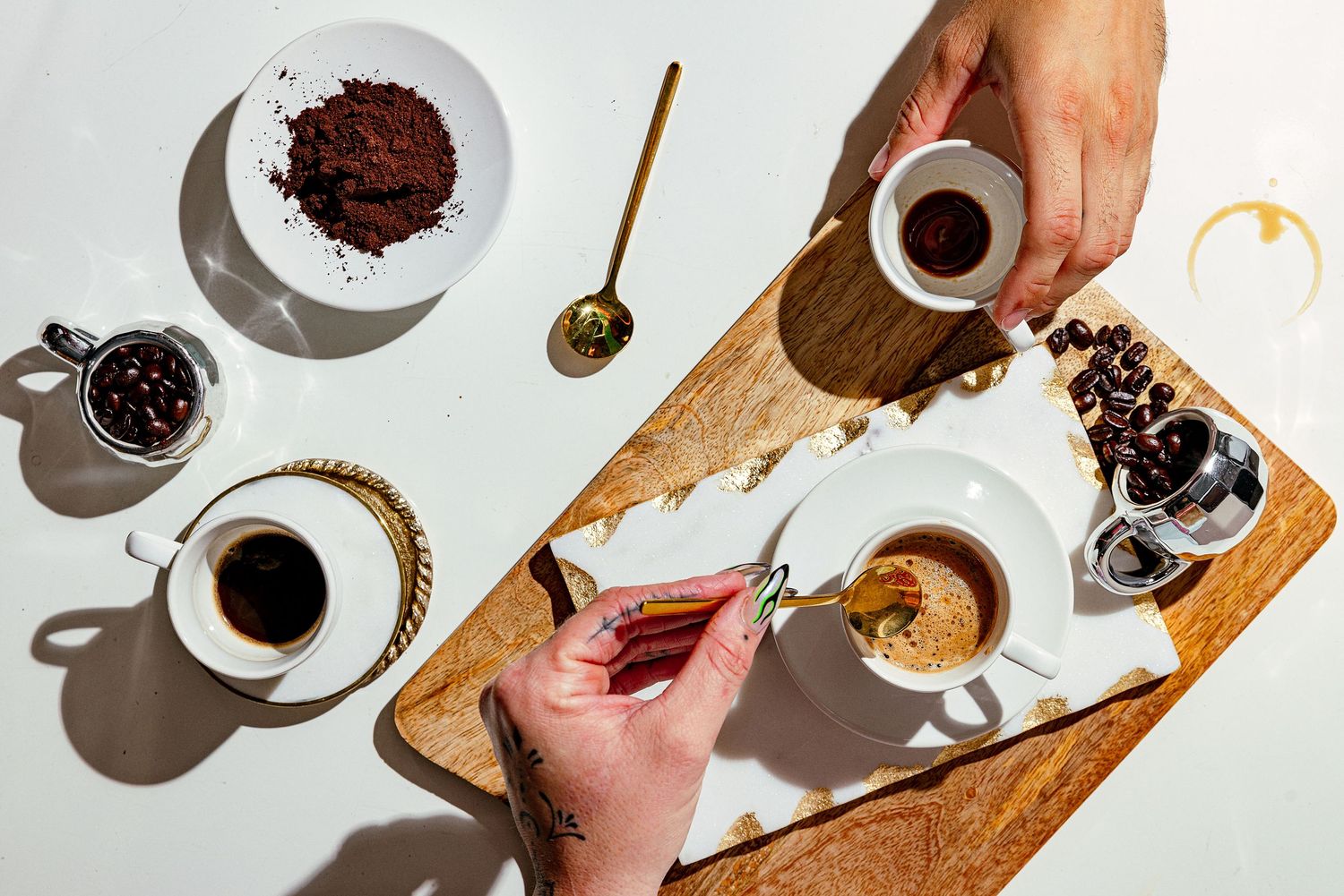 Food and beverage photography for a local business in South Florida of espresso preparation with hands styling coffee cups and cocoa powder.
