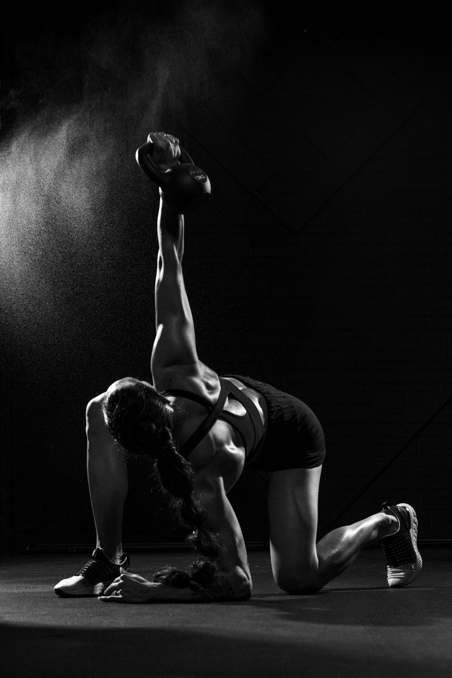 black and white studio photography of Hannah Eden holding a kettlebell and wearing athleisure