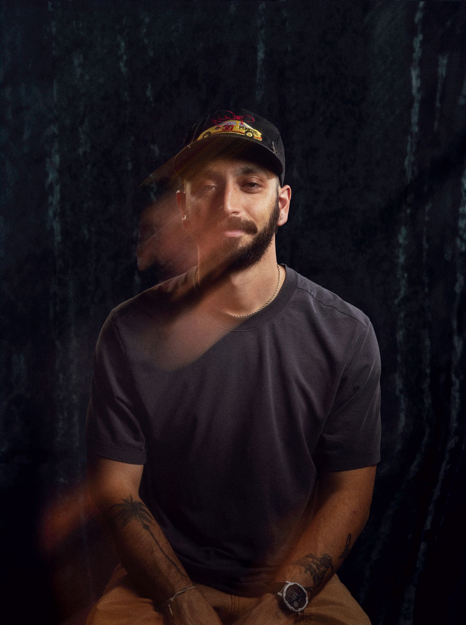 Creative portrait of associate photographer with motion blur effect, seated against moody velvet backdrop.
