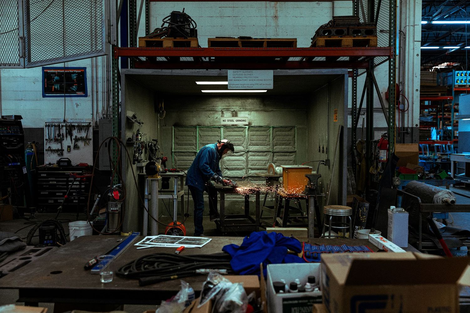 Corporate manufacturing photography of a technician fabricating metal components in an industrial facility for brand storytelling.
