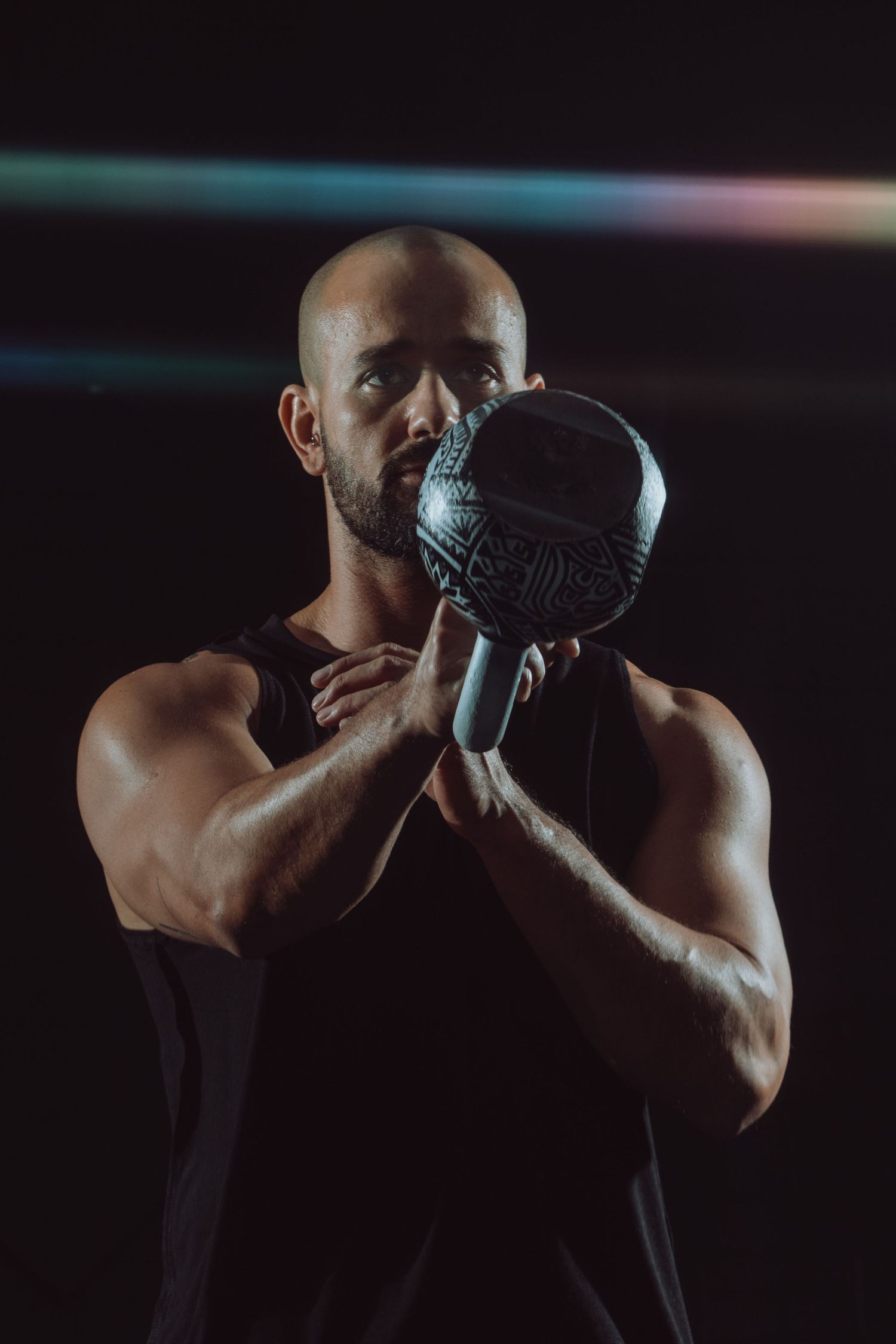 dramatic fitness photography of male athlete swinging a kettle bell in a South Florida photo studio