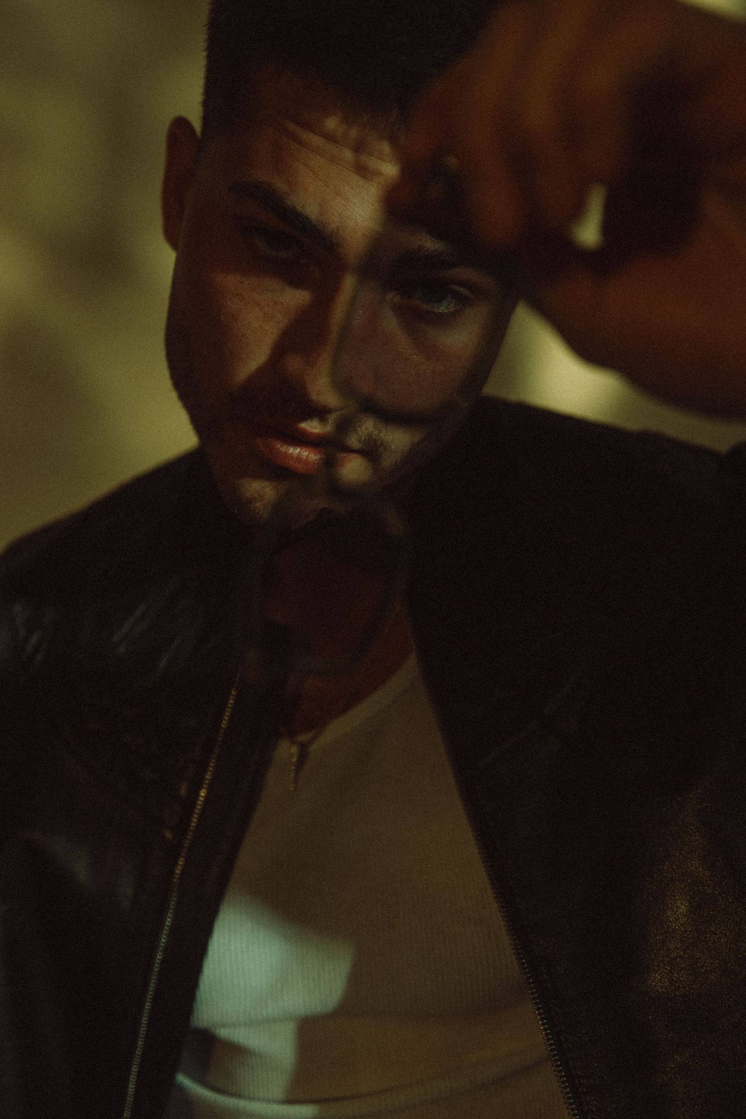 Edgy studio portrait of high end male model as part of a men's editorial fashion campaign shot by commercial photographer
