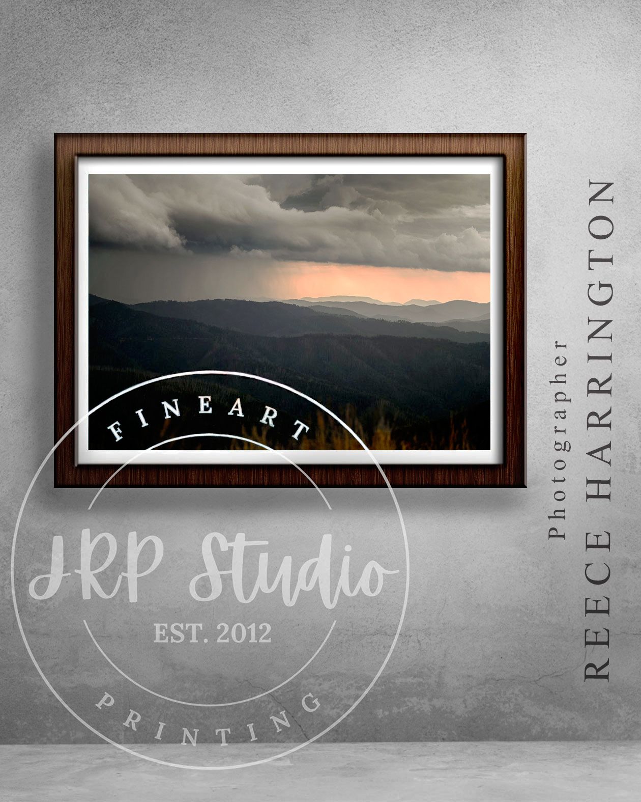 A landscape photograph by Reece Harrington custom printed on Ilford TCR by JRP Studio hanging in a brown wooden frame on a grey wall.