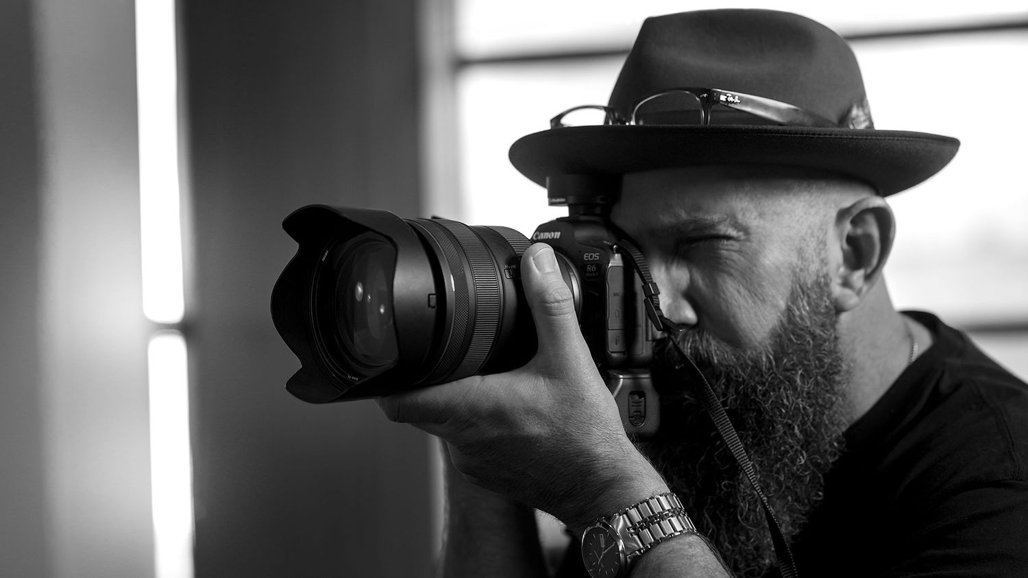 Profile photo of Albury Wodonga professional photographer Jason Robins in an Akubra hat holding a Canon EOS R6 mirrorless camera.