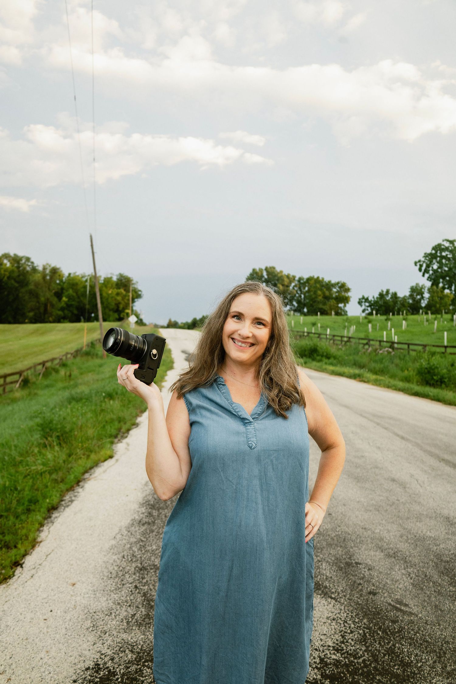 Nichole Sieck, a Marion photographer, stands with her camera on a paved country road.