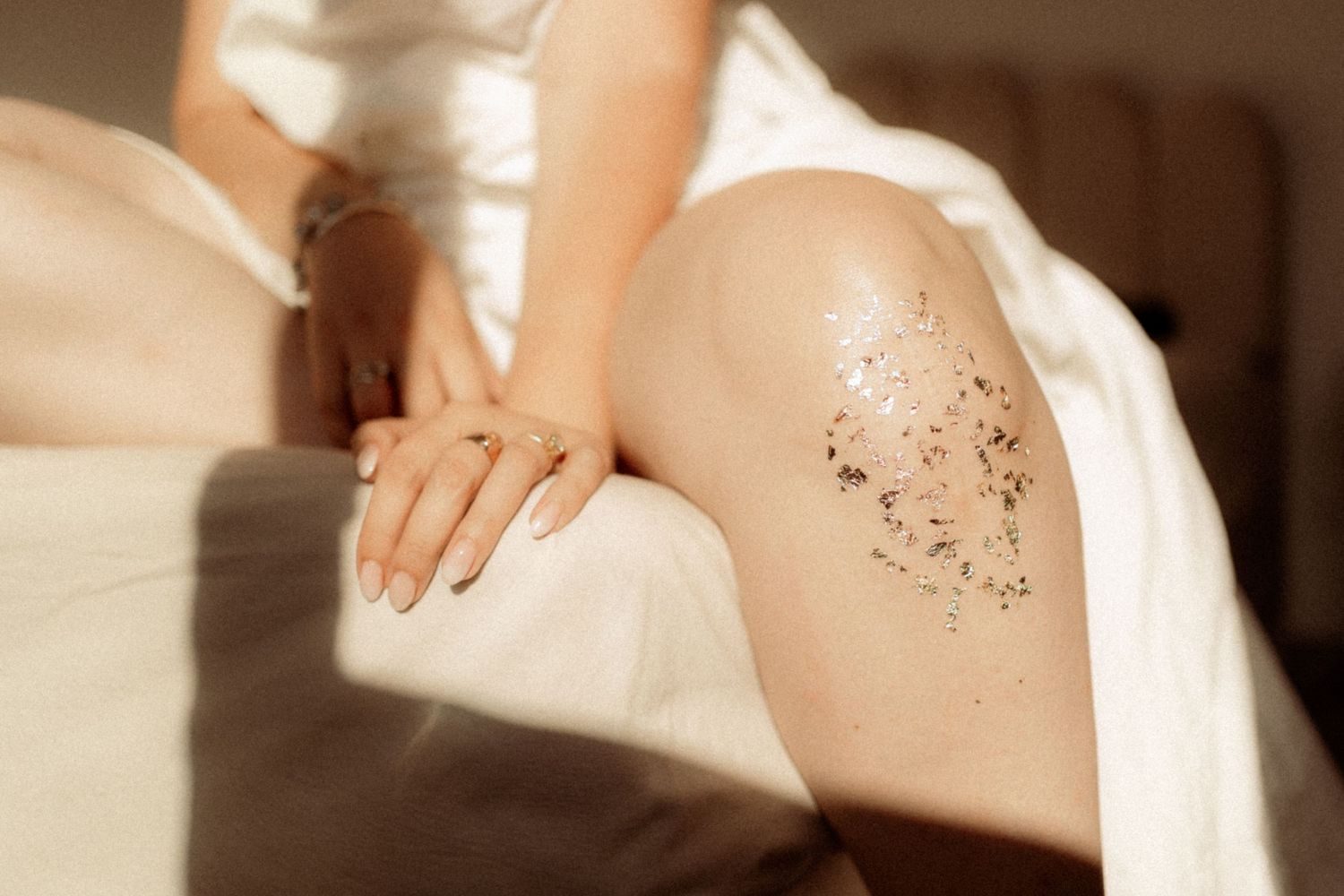 Artistic close-up of skin with decorative temporary tattoos in warm sunlight.