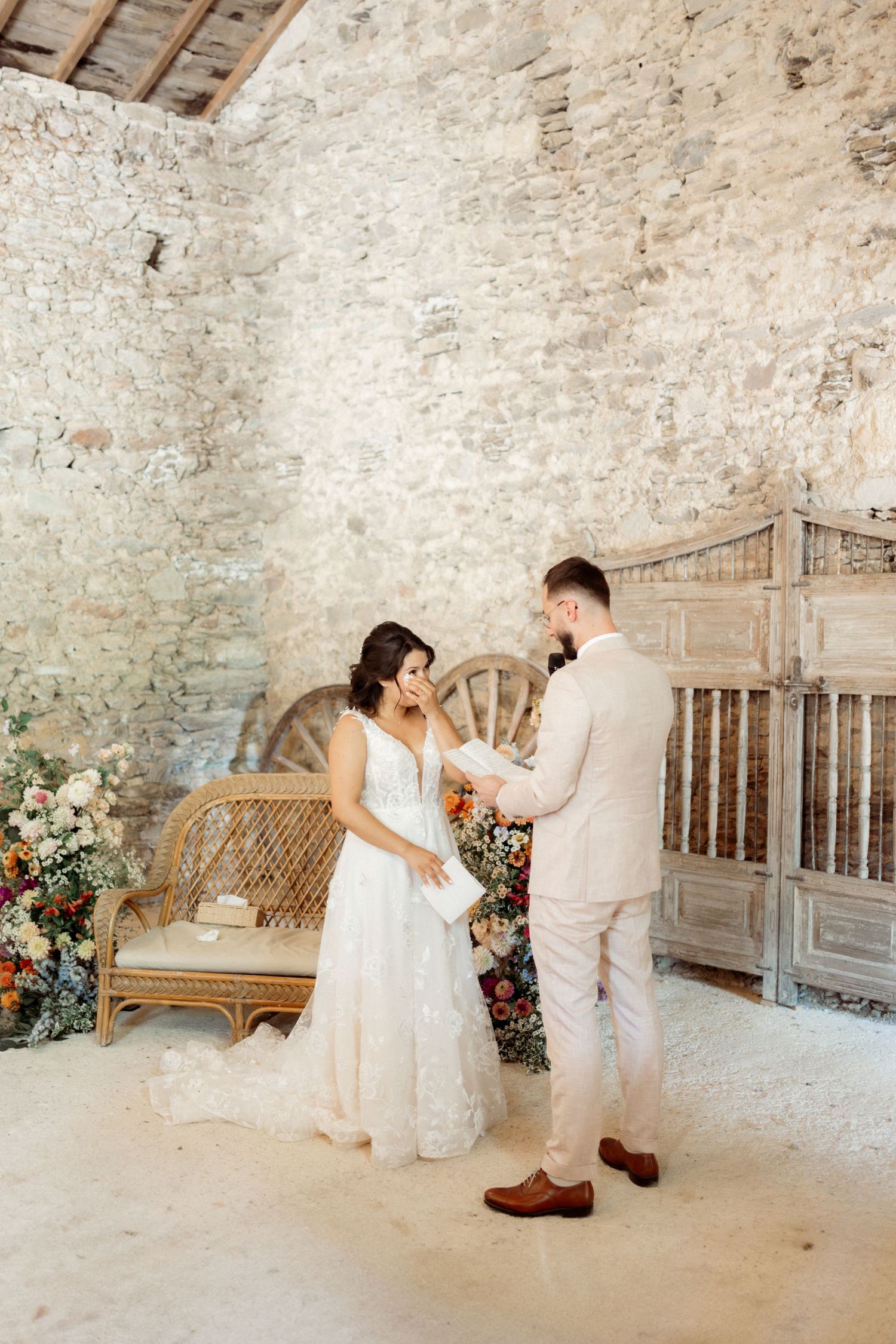A romantic moment captured in a rustic stone room with vintage wooden decor and floral arrangements.