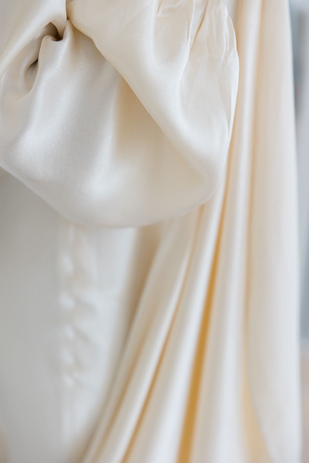 Soft white fabric with gentle folds and creases creates an elegant drapery texture background.