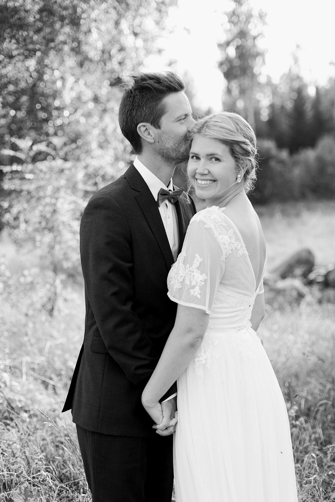A romantic black and white wedding photo series showing tender moments between newlyweds in a natural outdoor setting.
