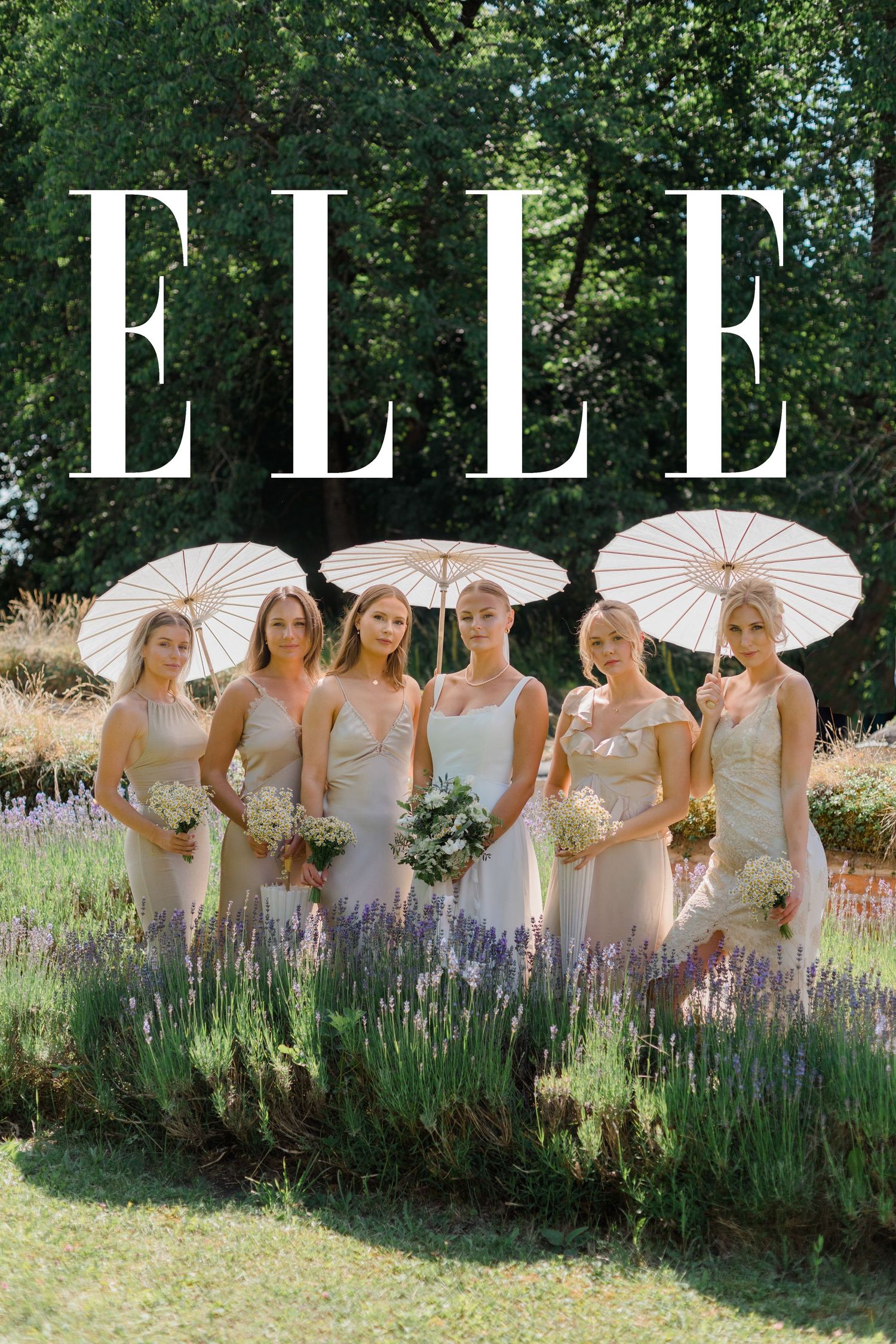 Bridesmaids in elegant champagne dresses pose with white parasols against a blooming lavender garden beneath the ELLE logo.