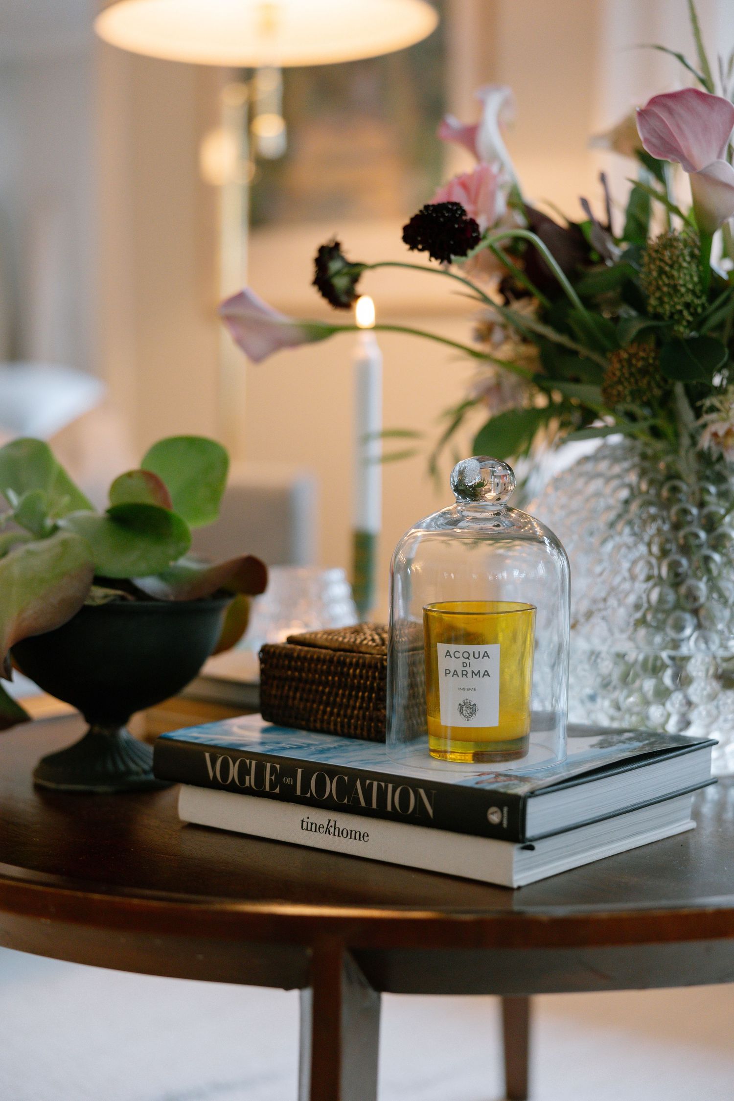 Decorative vignettes of books, candles, and small floral arrangements styled on wooden side tables create an elegant display.