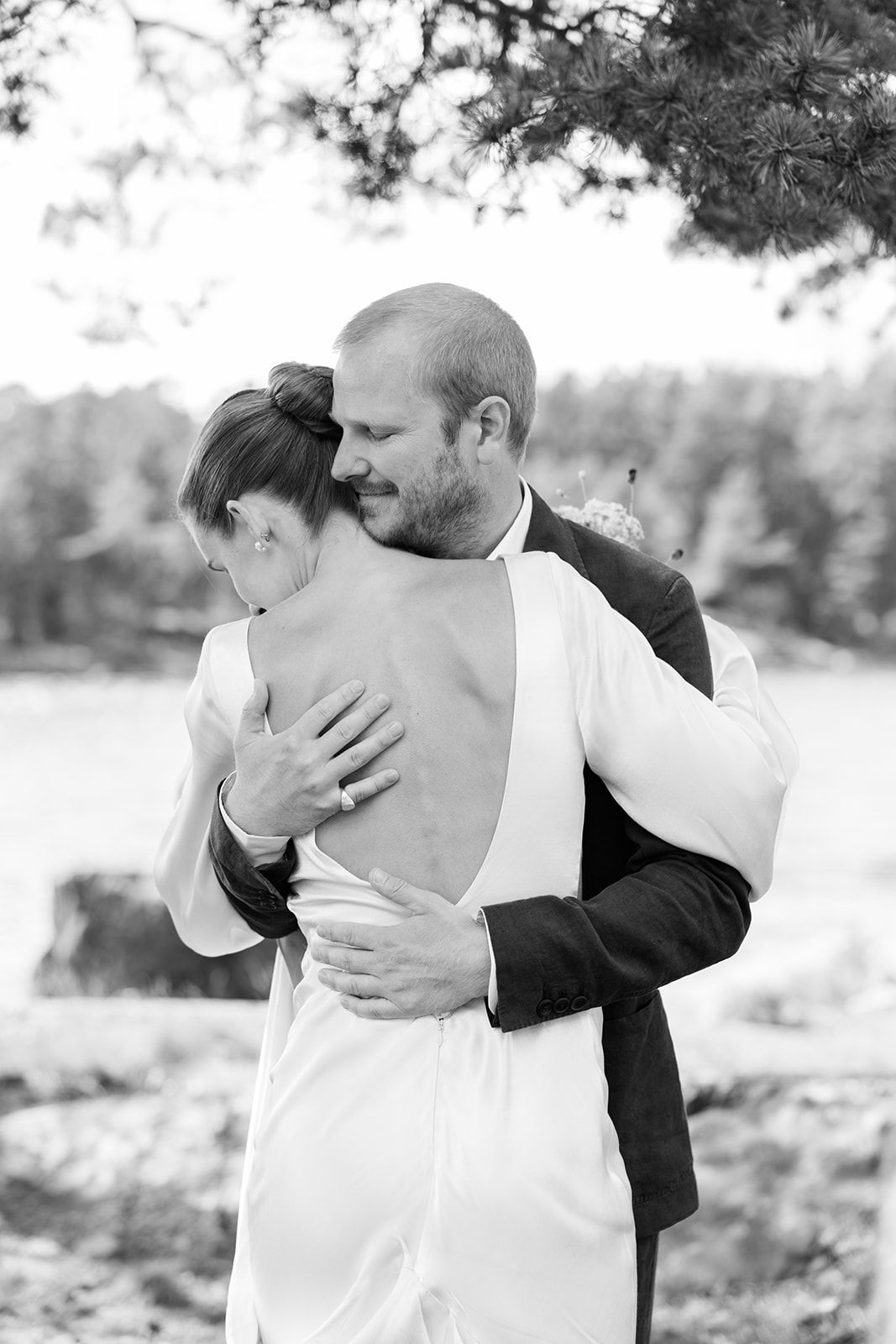 A romantic black and white photo series showing a couple embracing outdoors in an intimate moment.