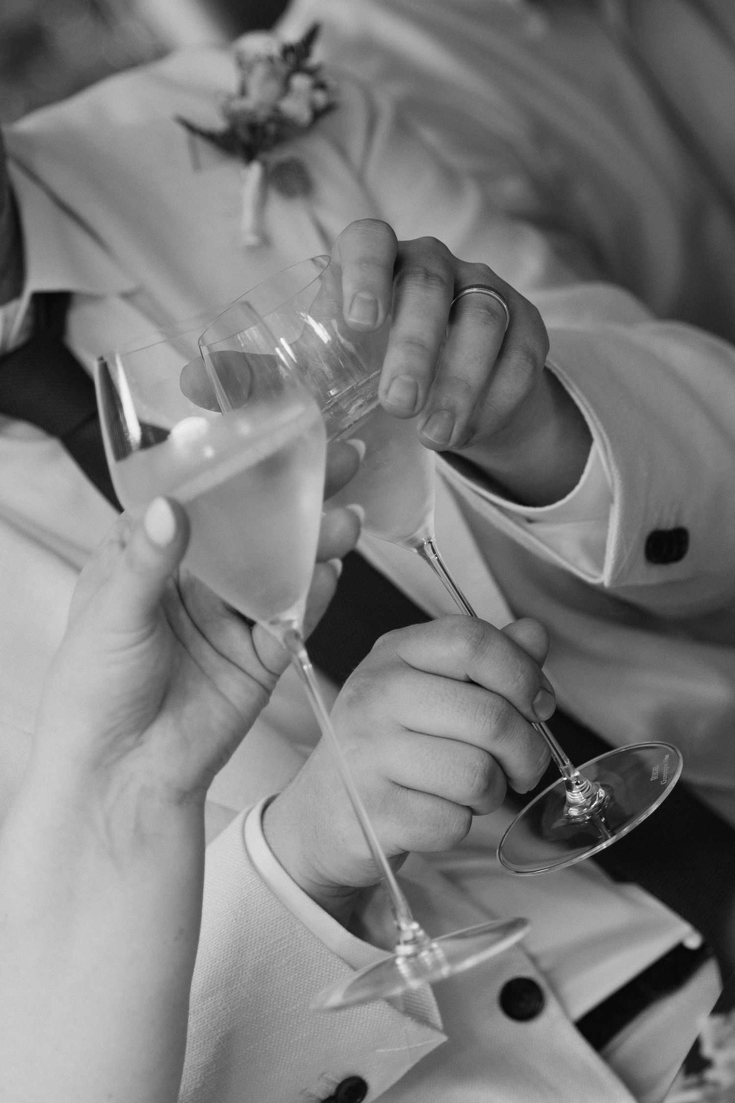 Black and white photograph of hands toasting with champagne glasses at a formal celebration, Charleston SC Wedding Photographer