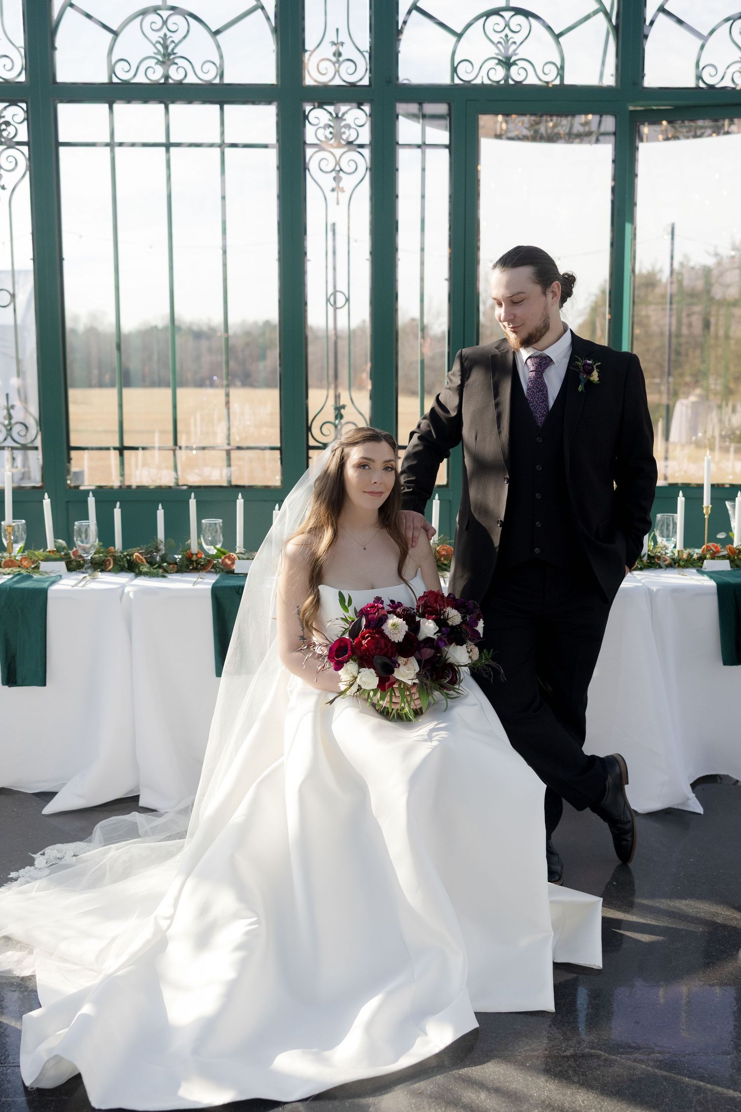 A bride and groom share intimate moments in a bright sunlit conservatory with ornate green metalwork and white decor.