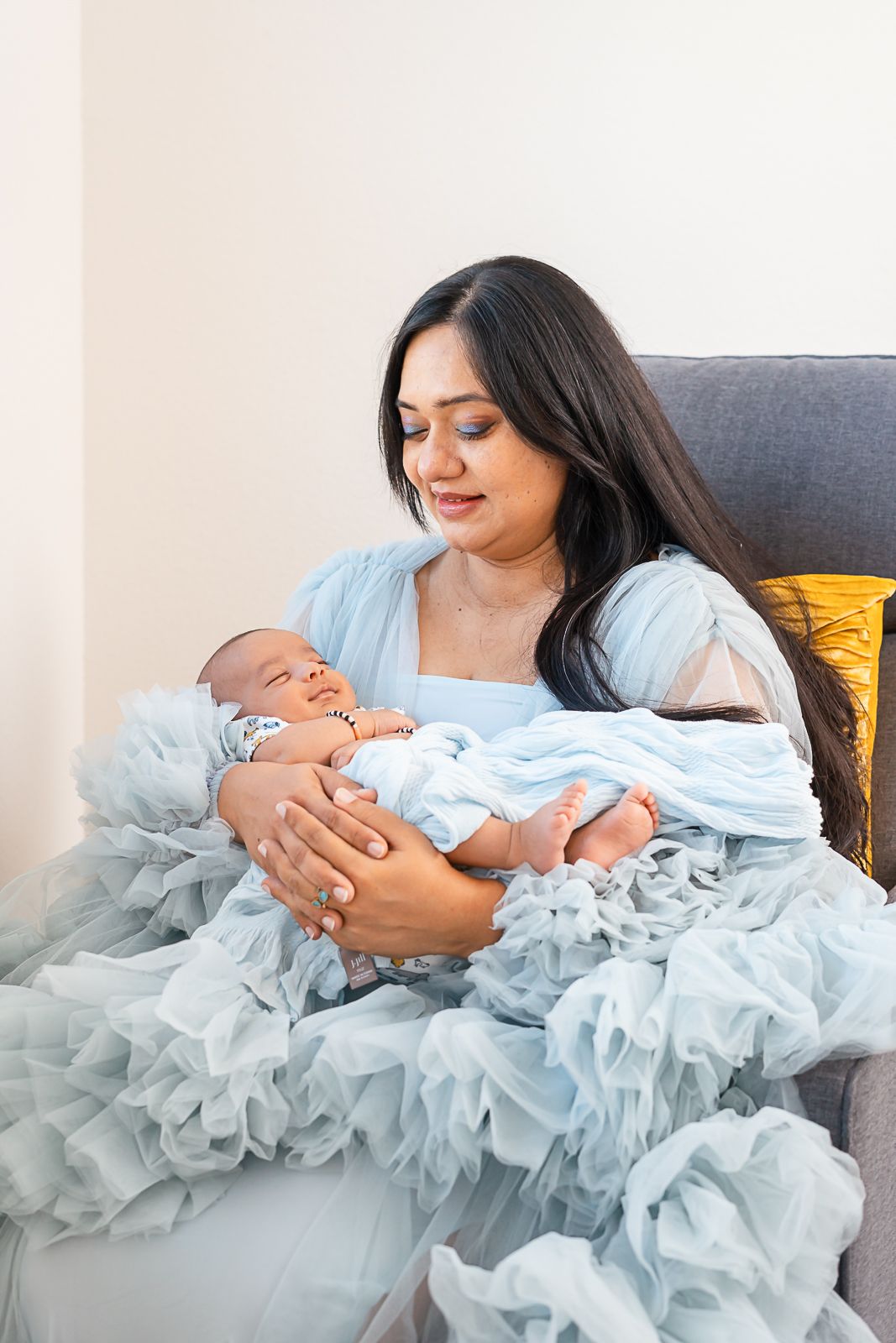 Mother holds her baby boy tenderly, basking in the joy of their in-home newborn photo session