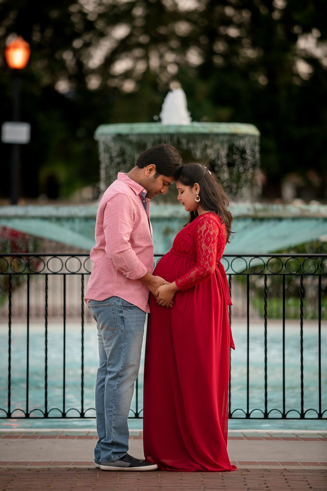 Maternity shoot near fountain at San Jose Rose Garden with couple holding the bump maternity photo pose idea by pixels by pari