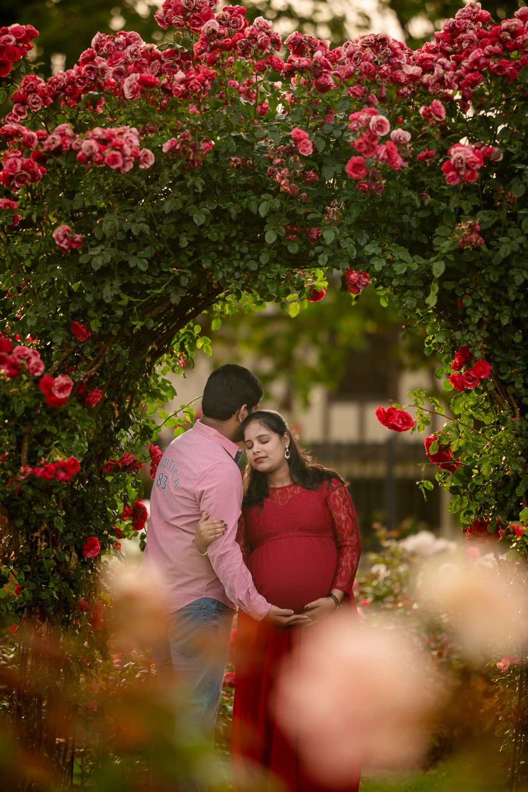 Walking through rose arches in Bay Area Rose garden portrait session by pixelsbypari