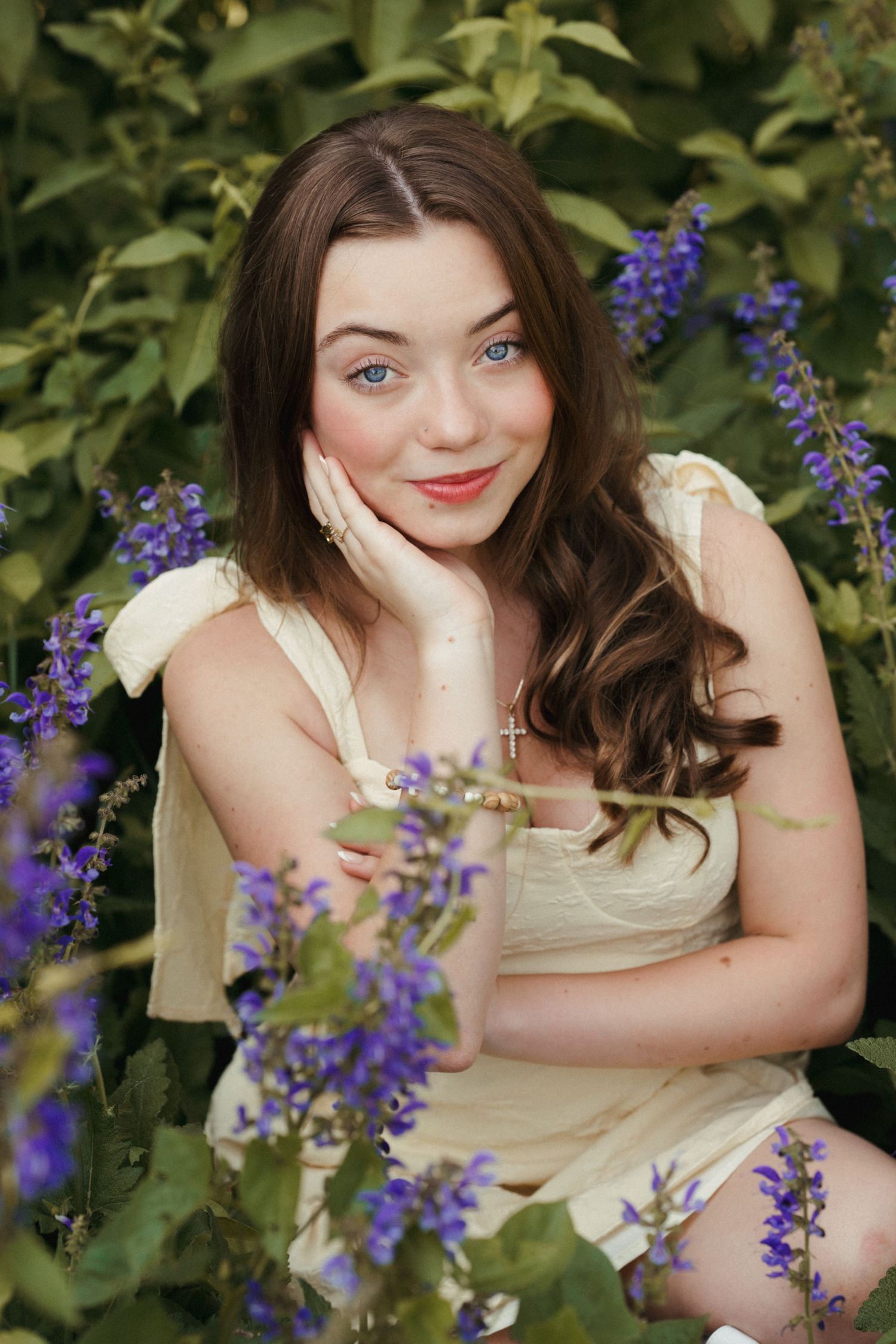Senior girl in purple wildflowers wearing a yellow sundress during a Brookings senior photo session.