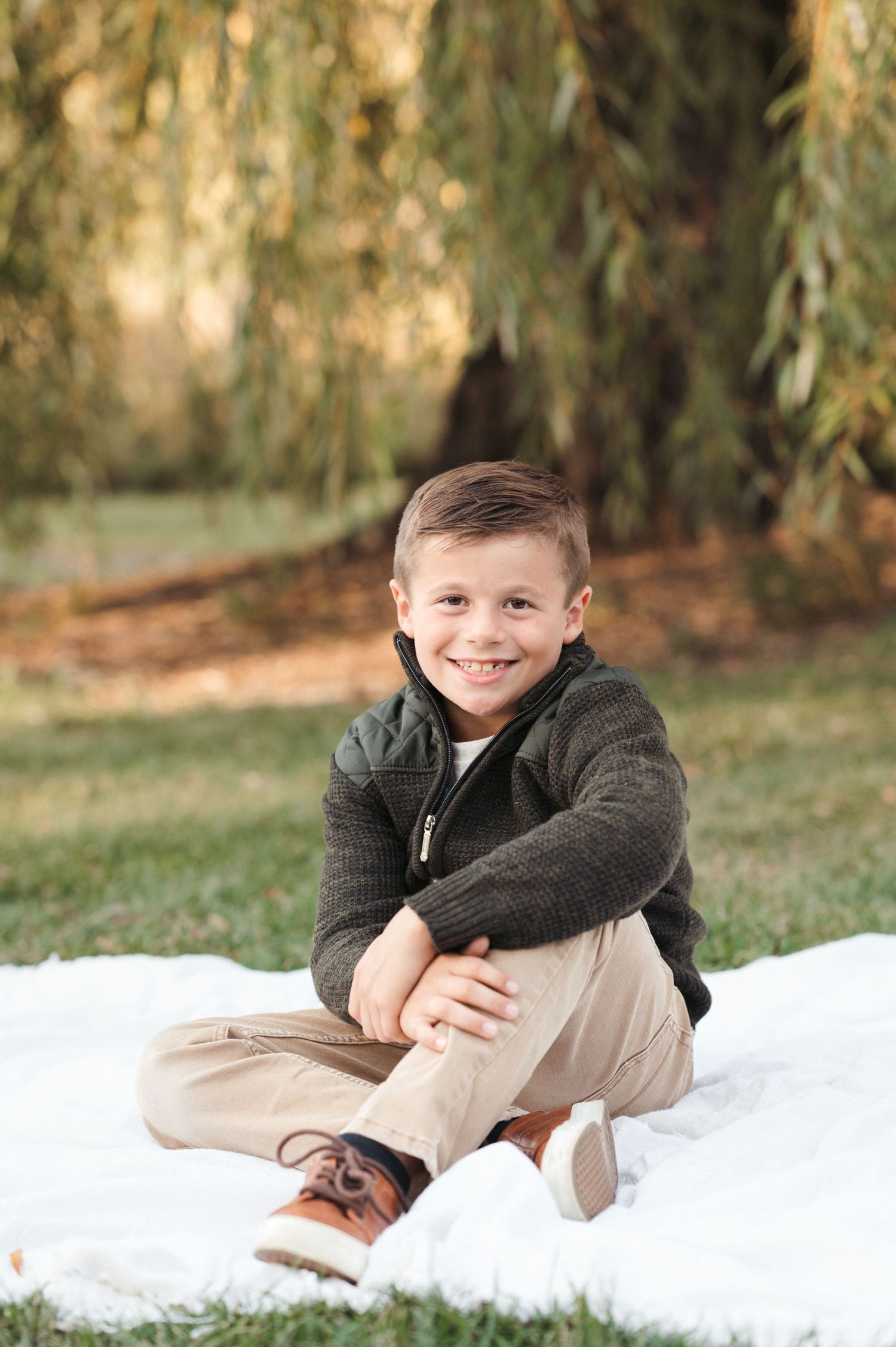 Natural light milestone session in Brookings, SD with a young boy and soft green hues.