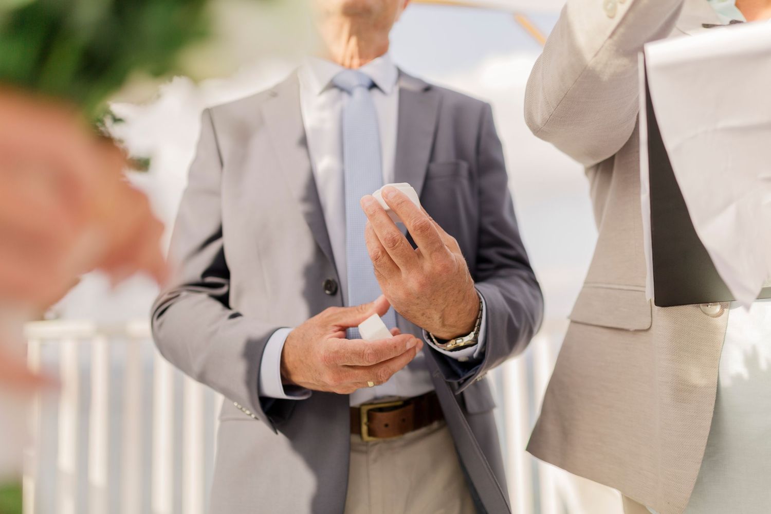 Close-up of hands during a wedding ring exchange ceremony.