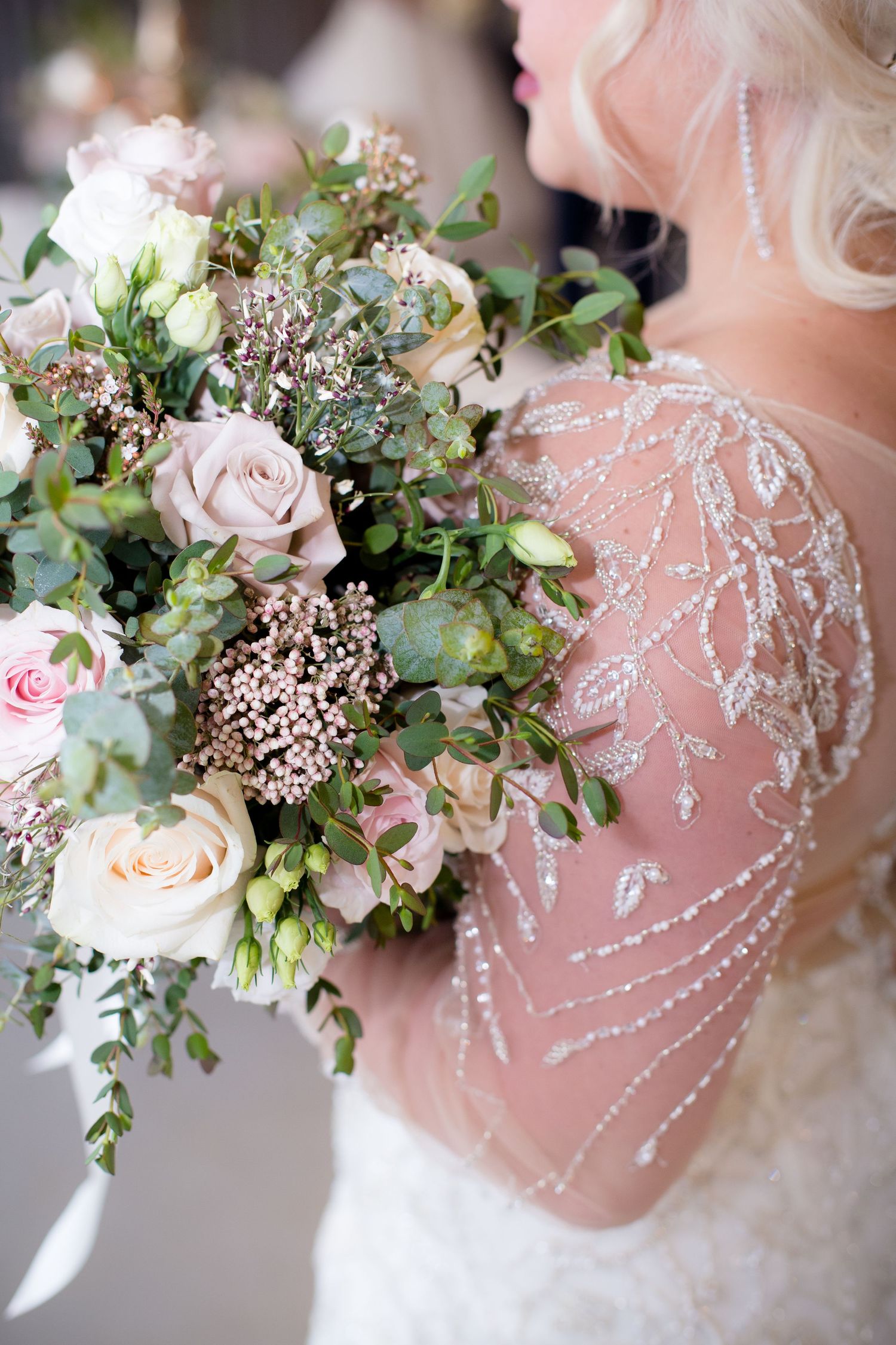 Bride in beaded lace wedding gown holding a romantic bouquet of blush roses and eucalyptus greenery in Chicago