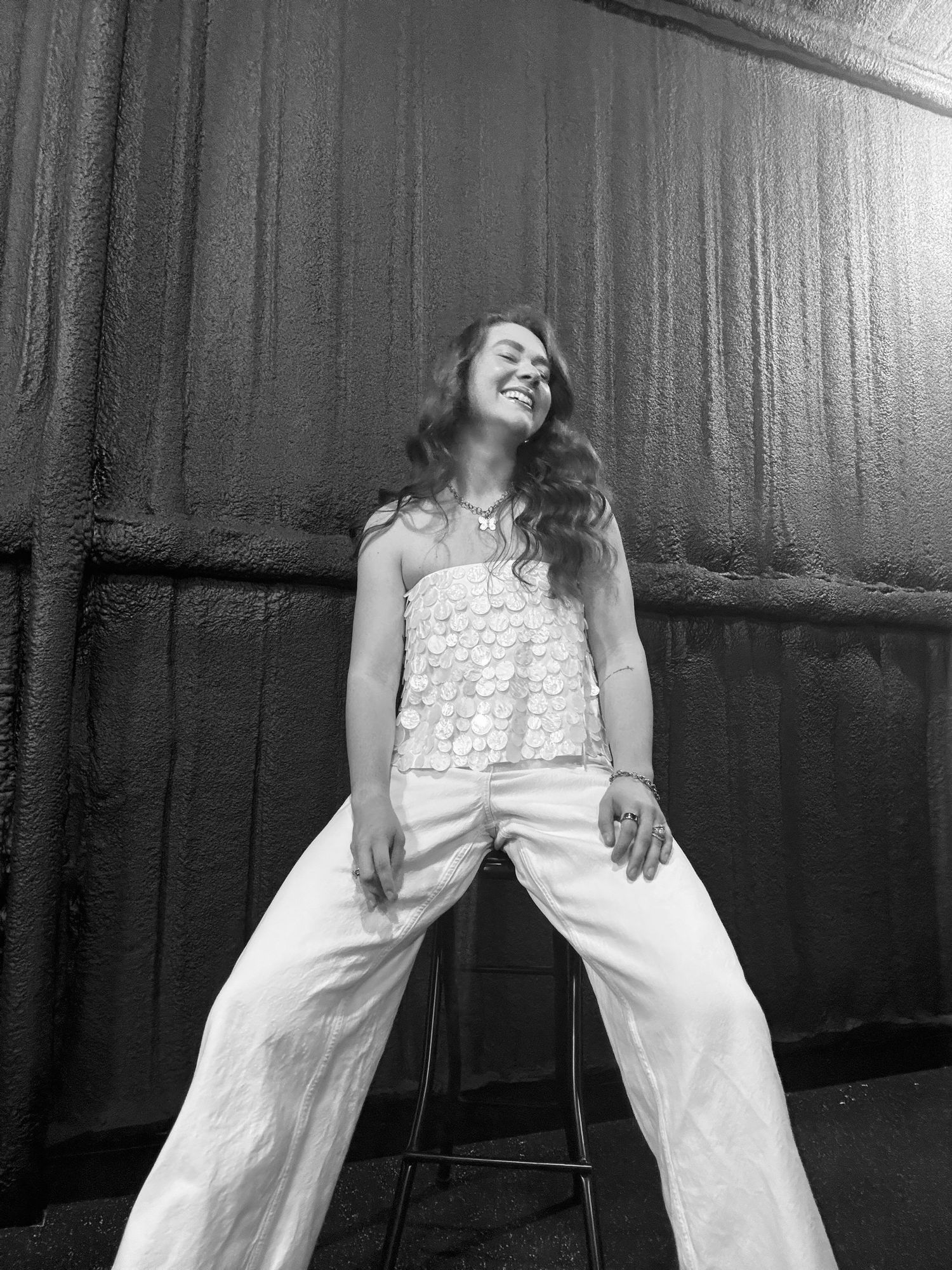 A sequence of black and white photos showing someone in a white dress seated on a chair in various poses.