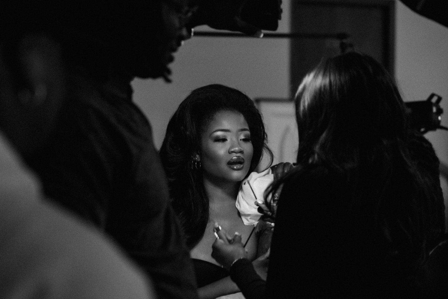 Black and white photo of a woman in conversation with others at a professional event.