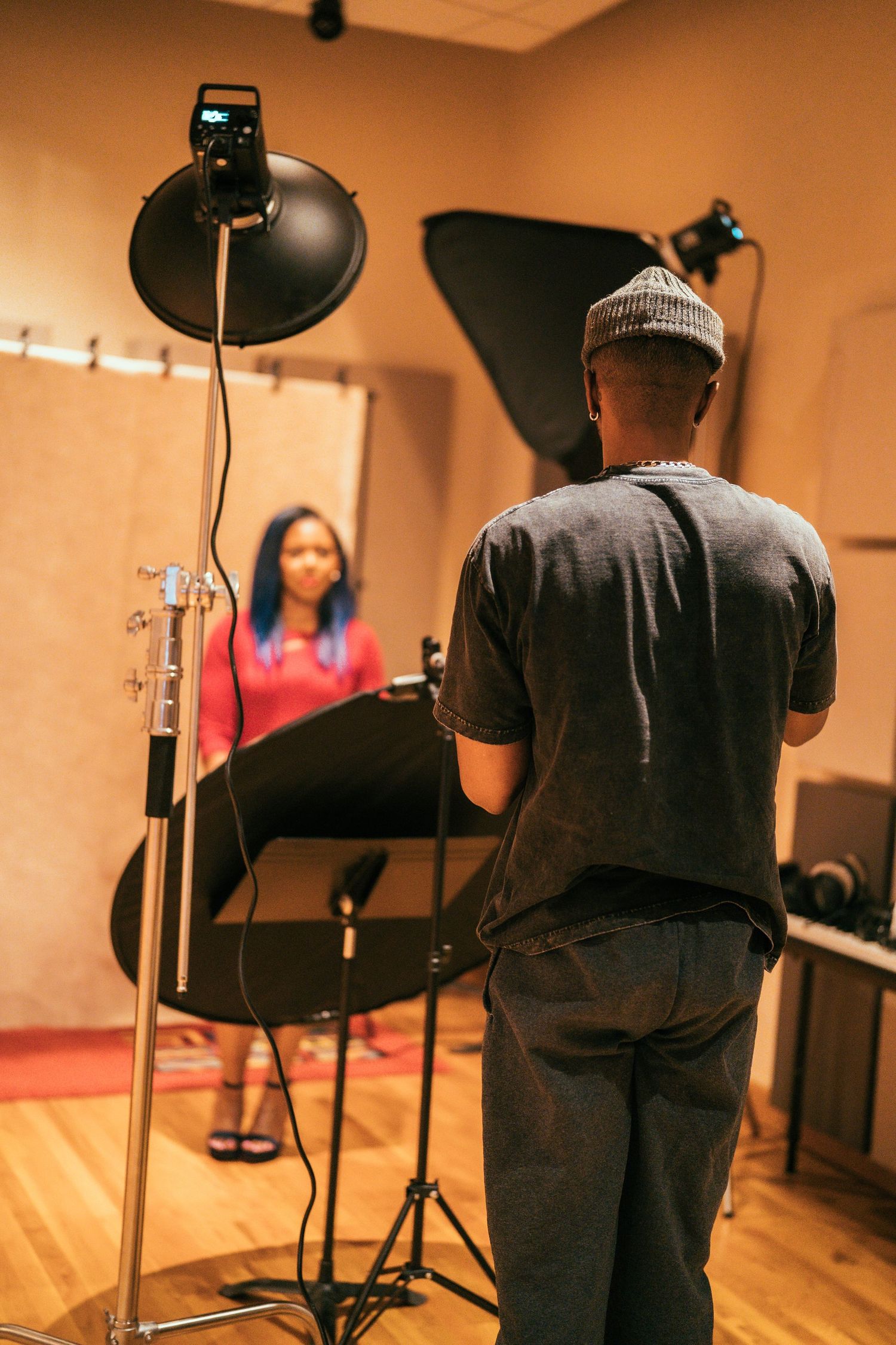 Photographer setting up lighting equipment for portrait session in studio.