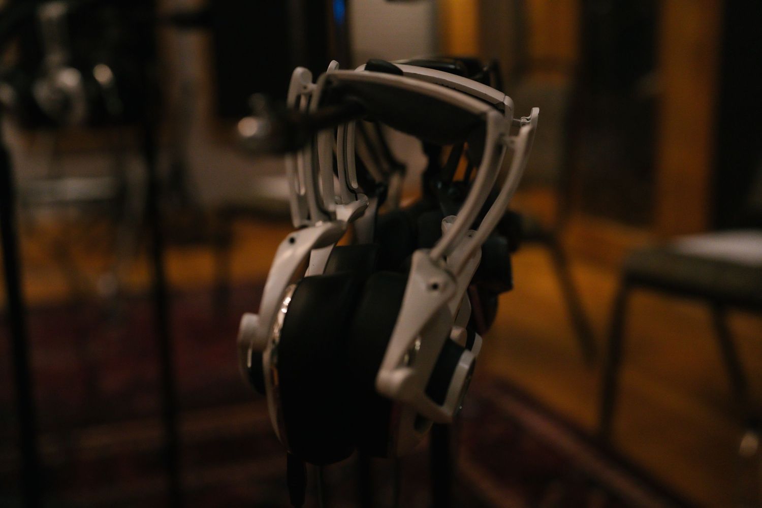 Professional studio headphones resting on stand in recording studio.