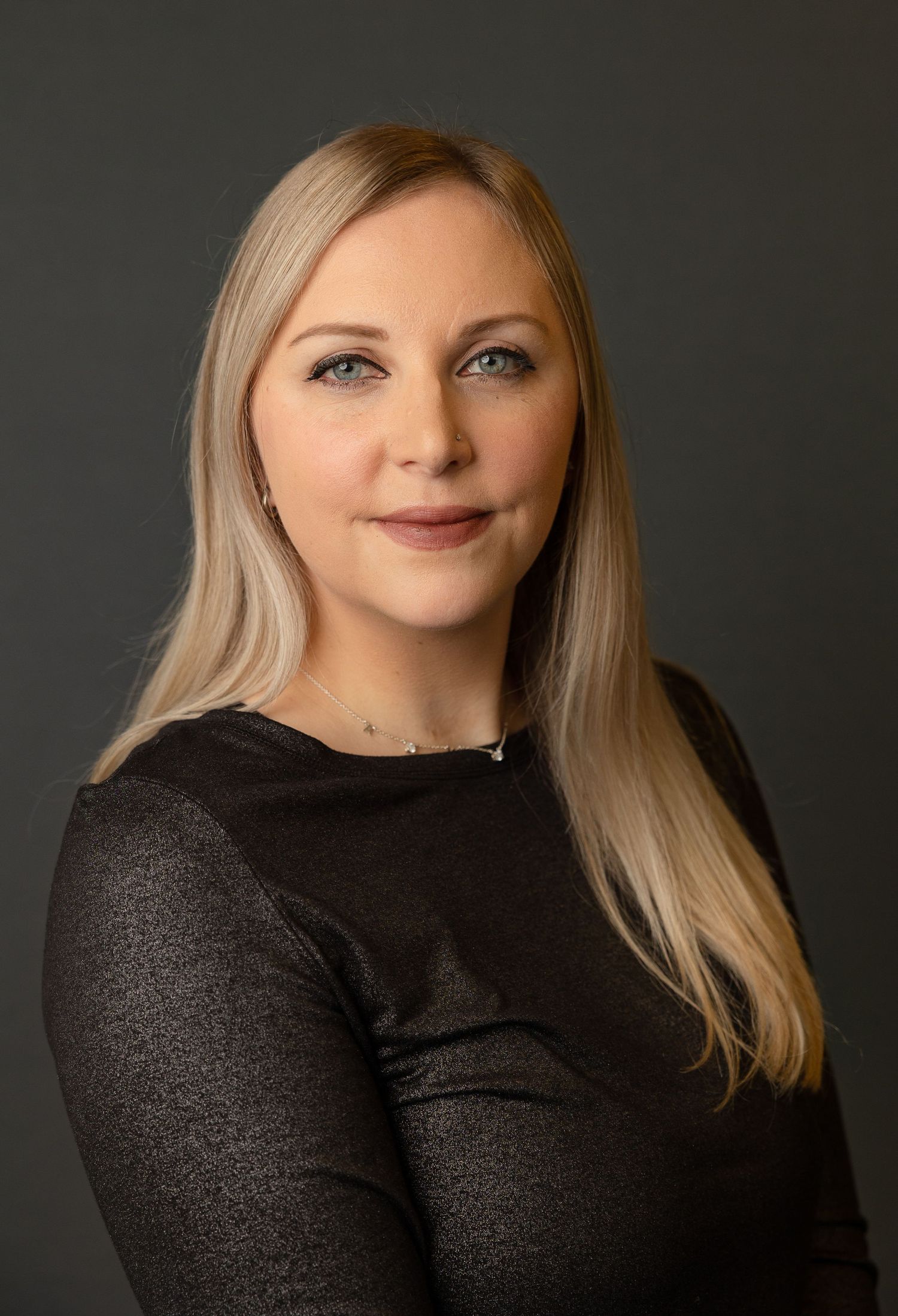 Studio portrait series featuring person in dark top against dramatic black background.