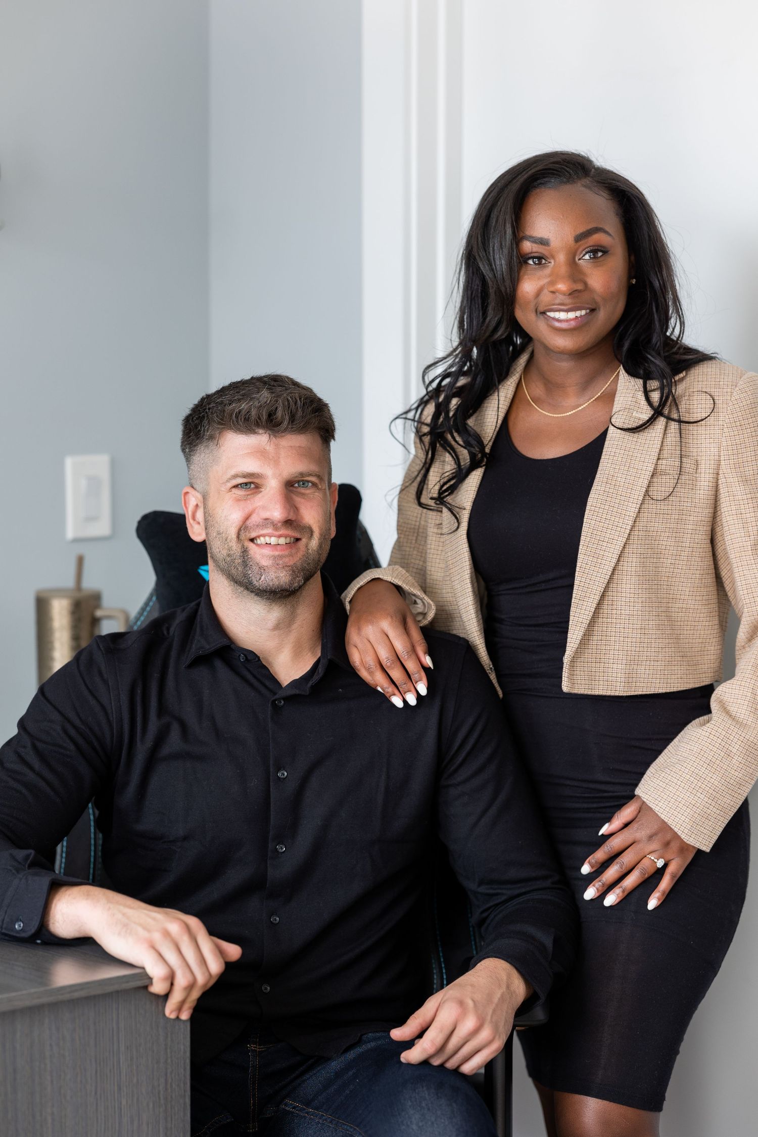 Professional colleagues posing together in modern office space with bright lighting.