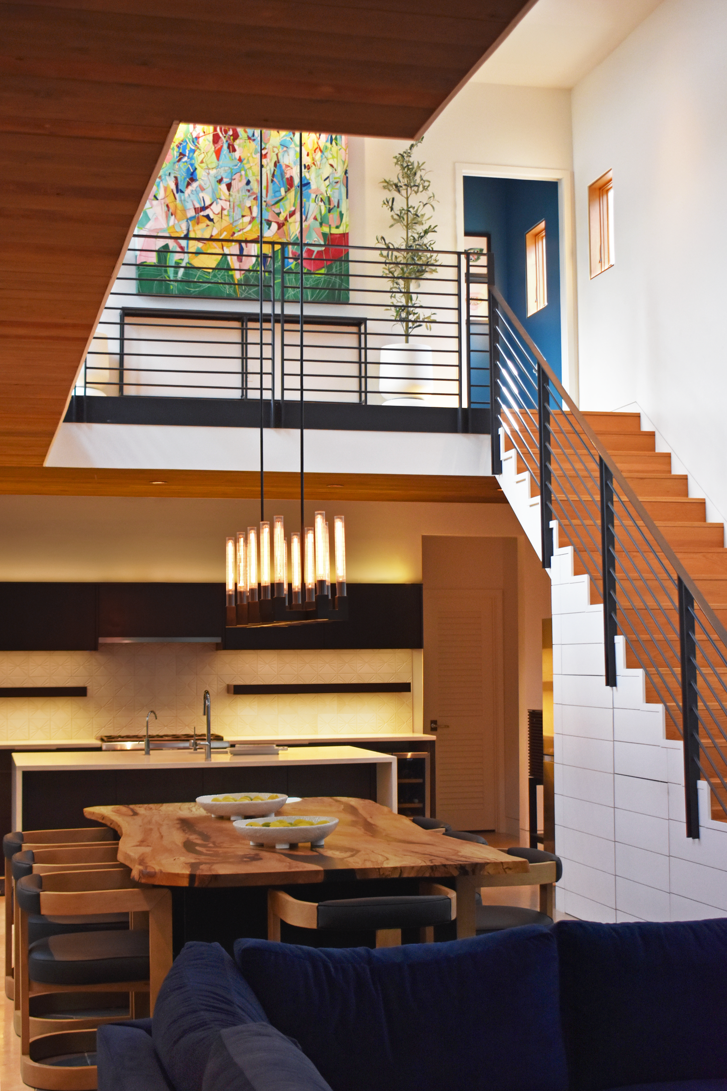 Modern home interior in downtown San Antonio featuring open floor plan, wood staircase, and stained glass window