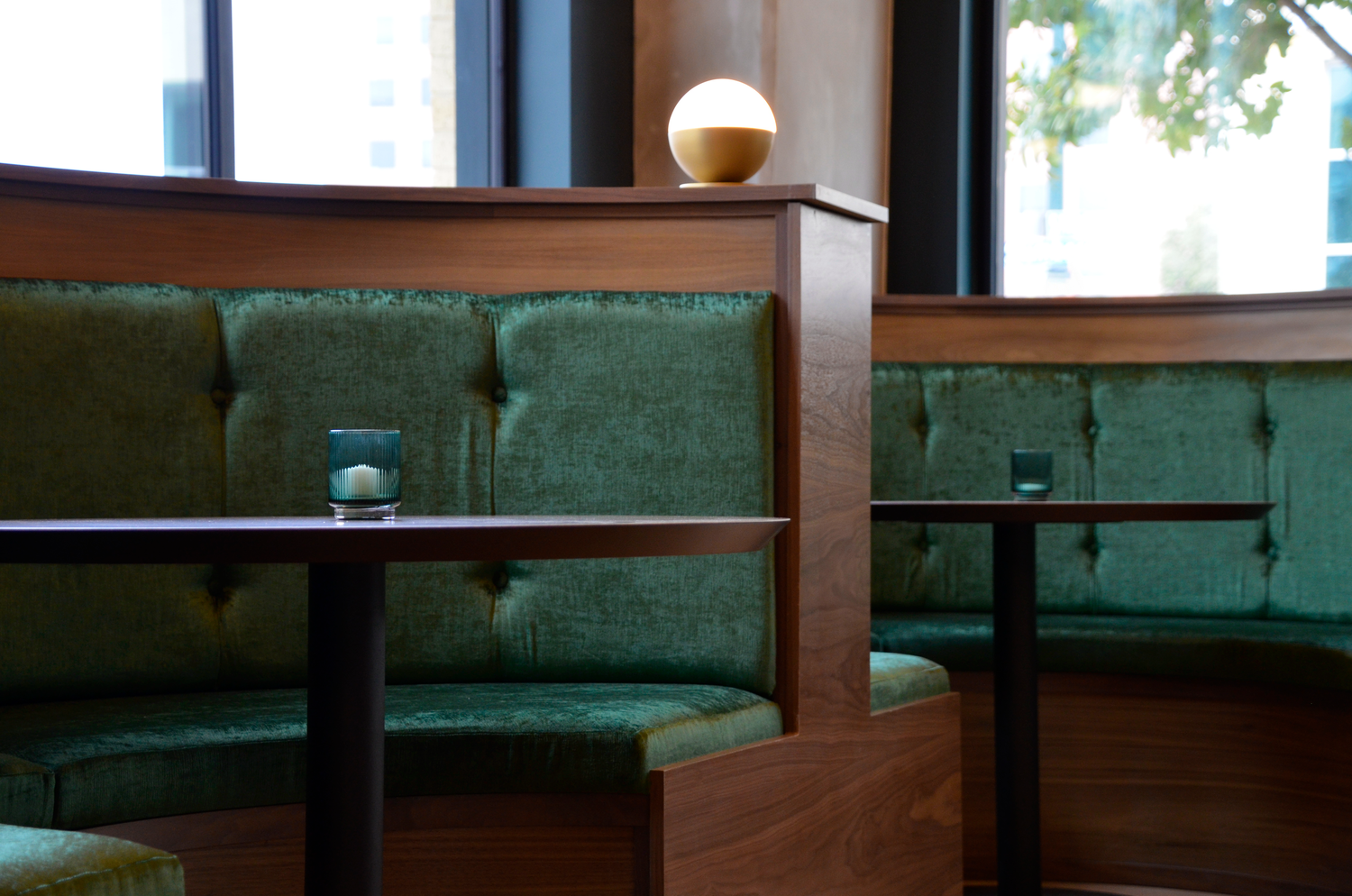 Coffee shop booth seating at Kafe Krave in downtown San Antonio with green velvet cushions and warm natural light