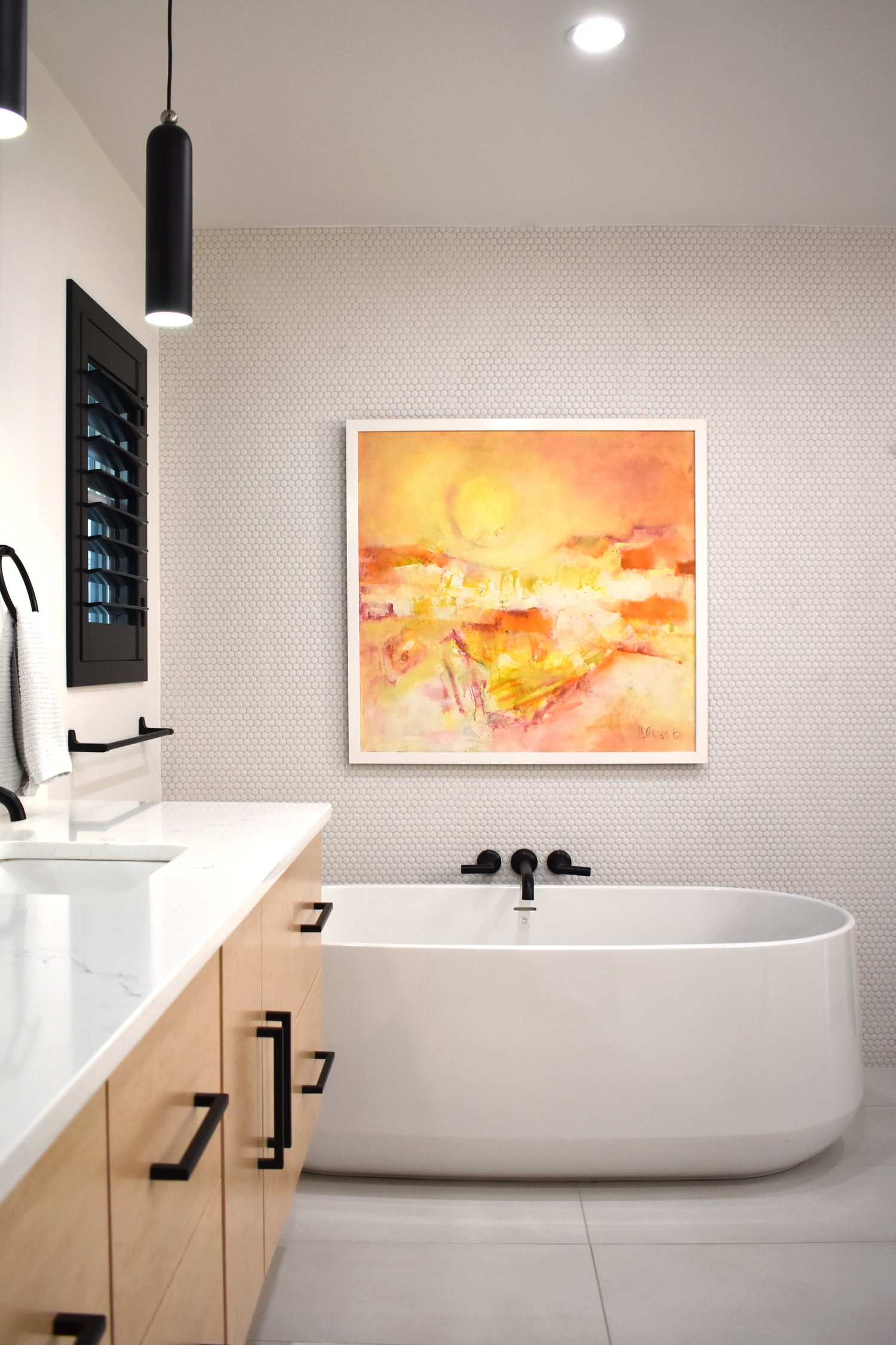 Residential bathroom interior in San Antonio with freestanding soaking tub and curated landscape artwork