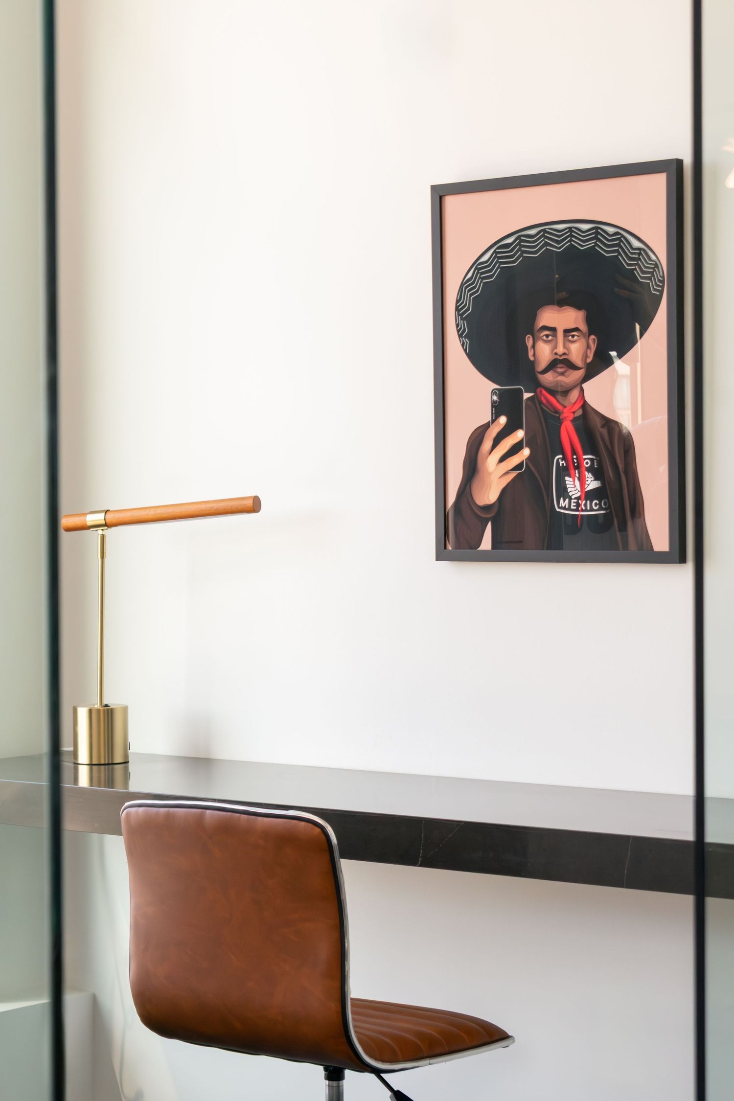 Office workspace interior at The Continental Residences in downtown San Antonio with curated portrait artwork